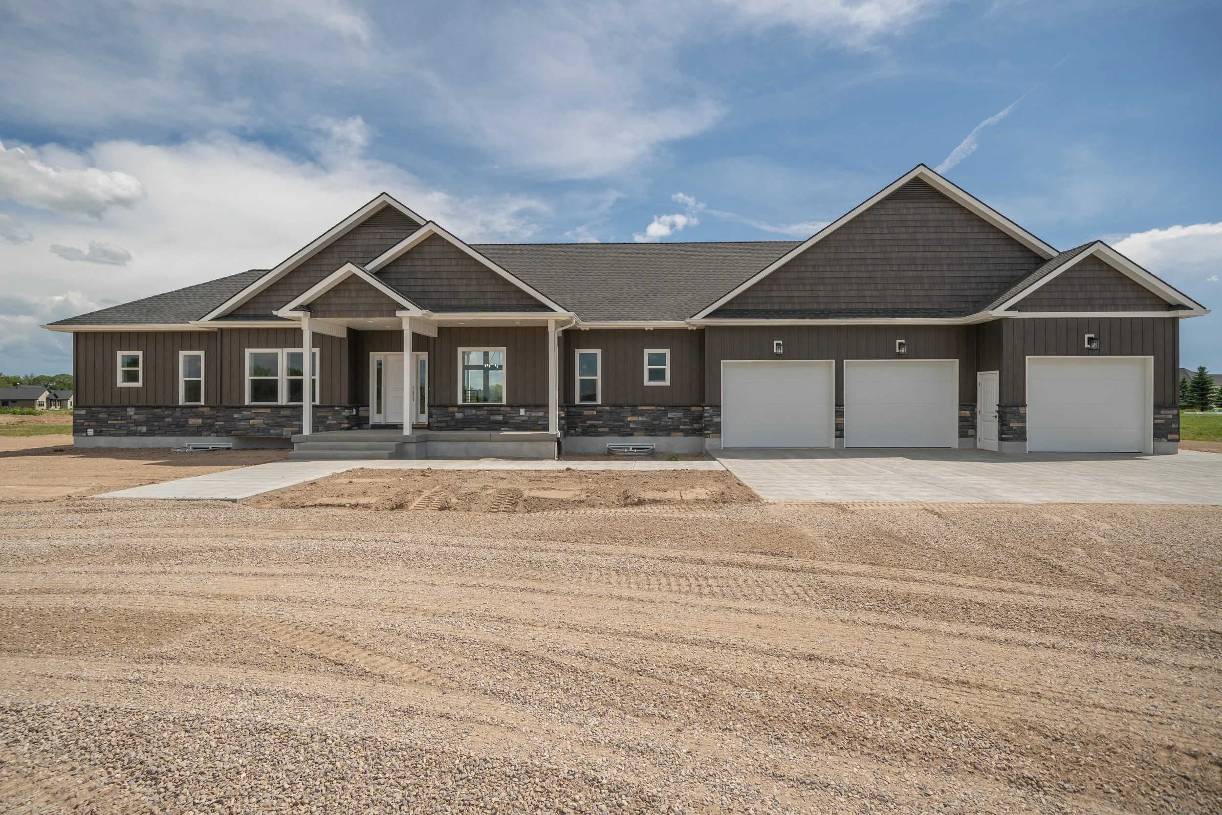 Front exterior with gabled rooflines and an attached three-car garage — JAB Construction’s Modern Craftsman custom home in Idaho Falls, Idaho.