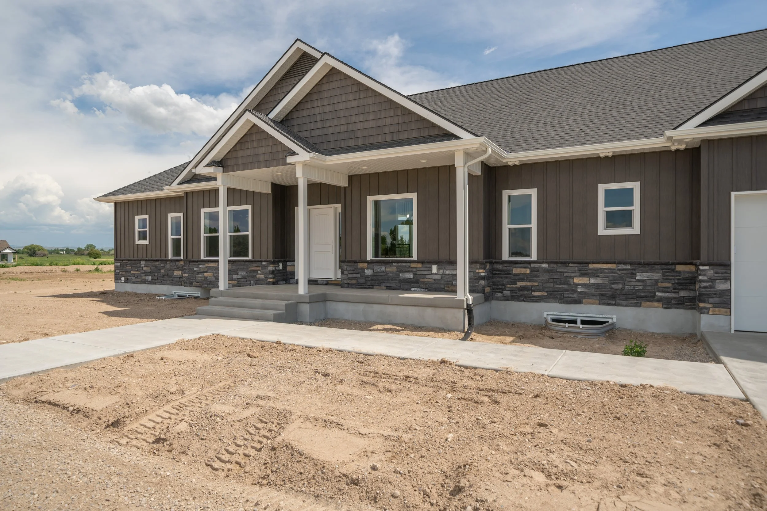 Covered front entrance with stone accents and white columns — JAB Construction’s Modern Craftsman custom home in Idaho Falls, Idaho.