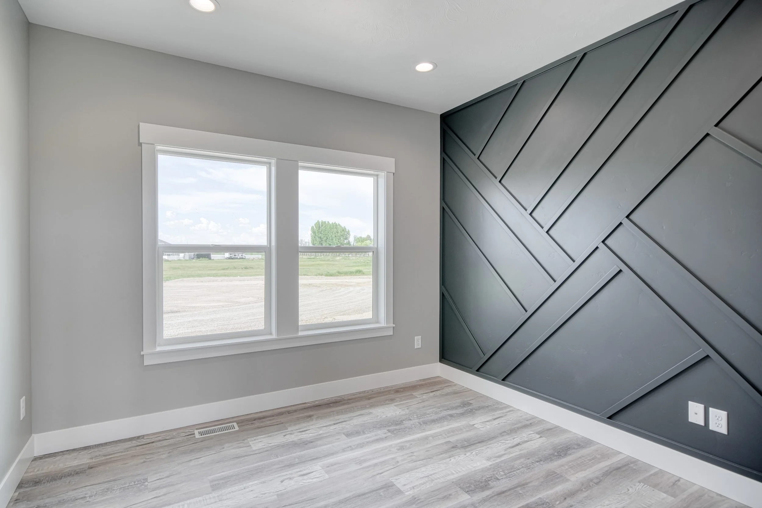 Room with large windows and a dark geometric accent wall — JAB Construction’s Modern Craftsman custom home in Idaho Falls, Idaho.