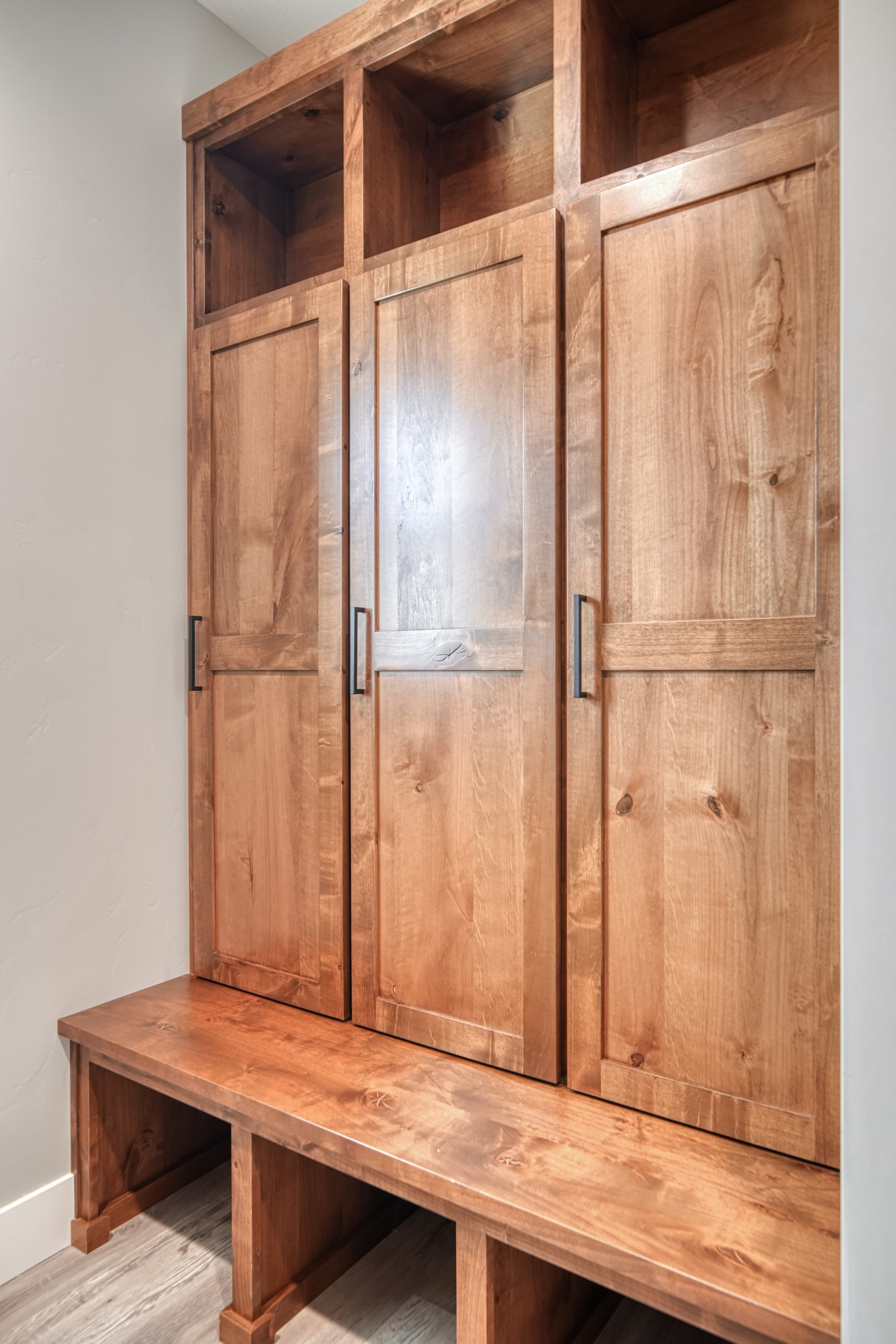 Wood entry bench with storage cabinets and coat hooks — JAB Construction’s Modern Craftsman custom home in Idaho Falls, Idaho.
