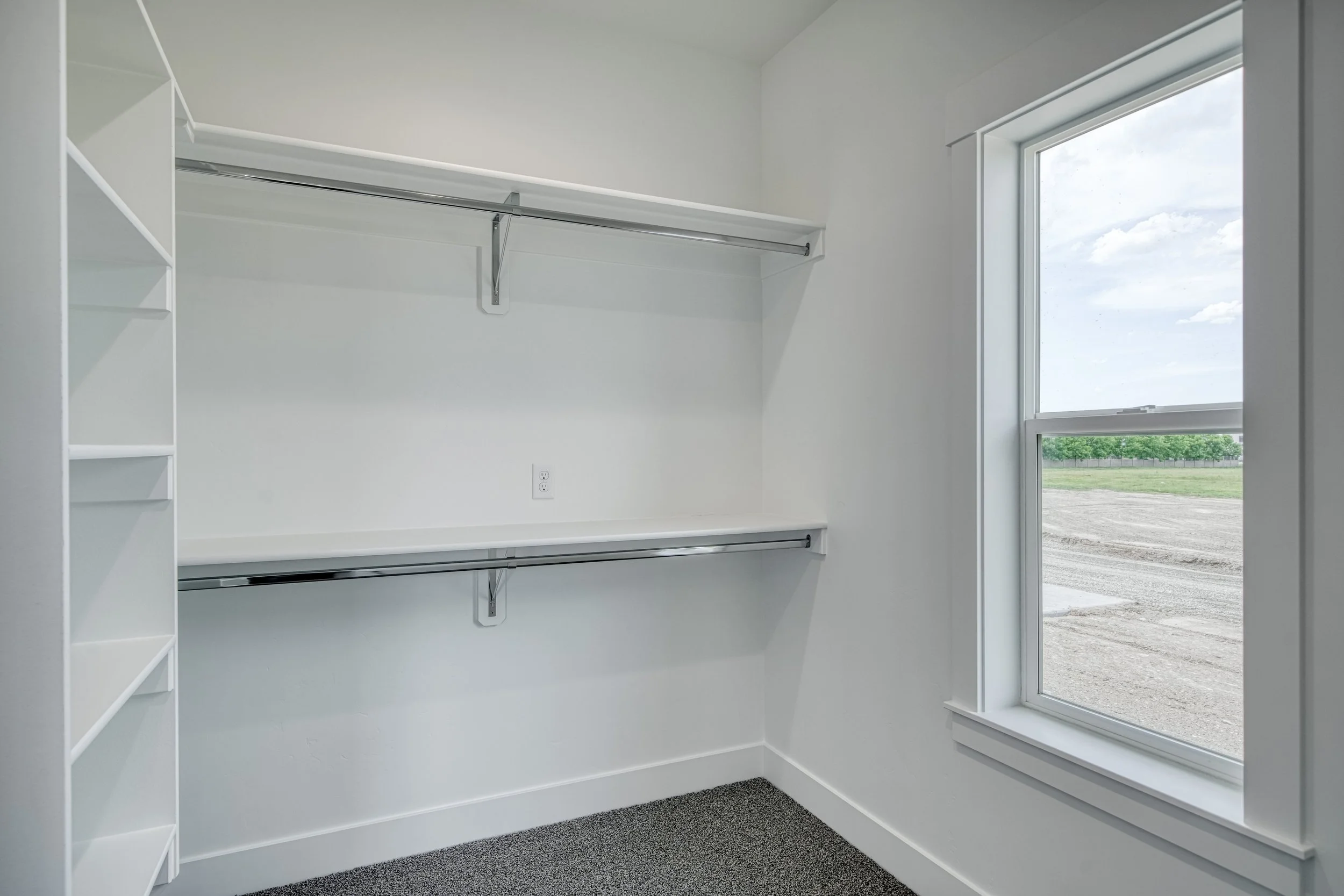 Walk-in closet with wall-mounted shelves and clothes rails — JAB Construction’s Modern Craftsman custom home in Idaho Falls, Idaho.