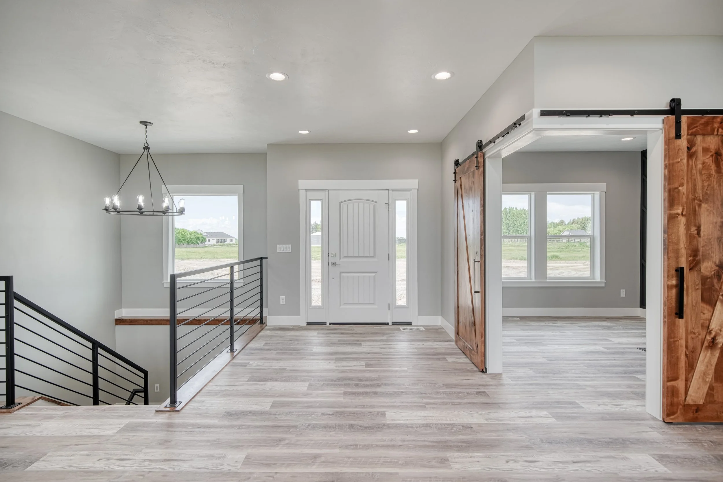 Entry hallway with wood-look flooring and white double doors — JAB Construction’s Modern Craftsman custom home in Idaho Falls, Idaho.