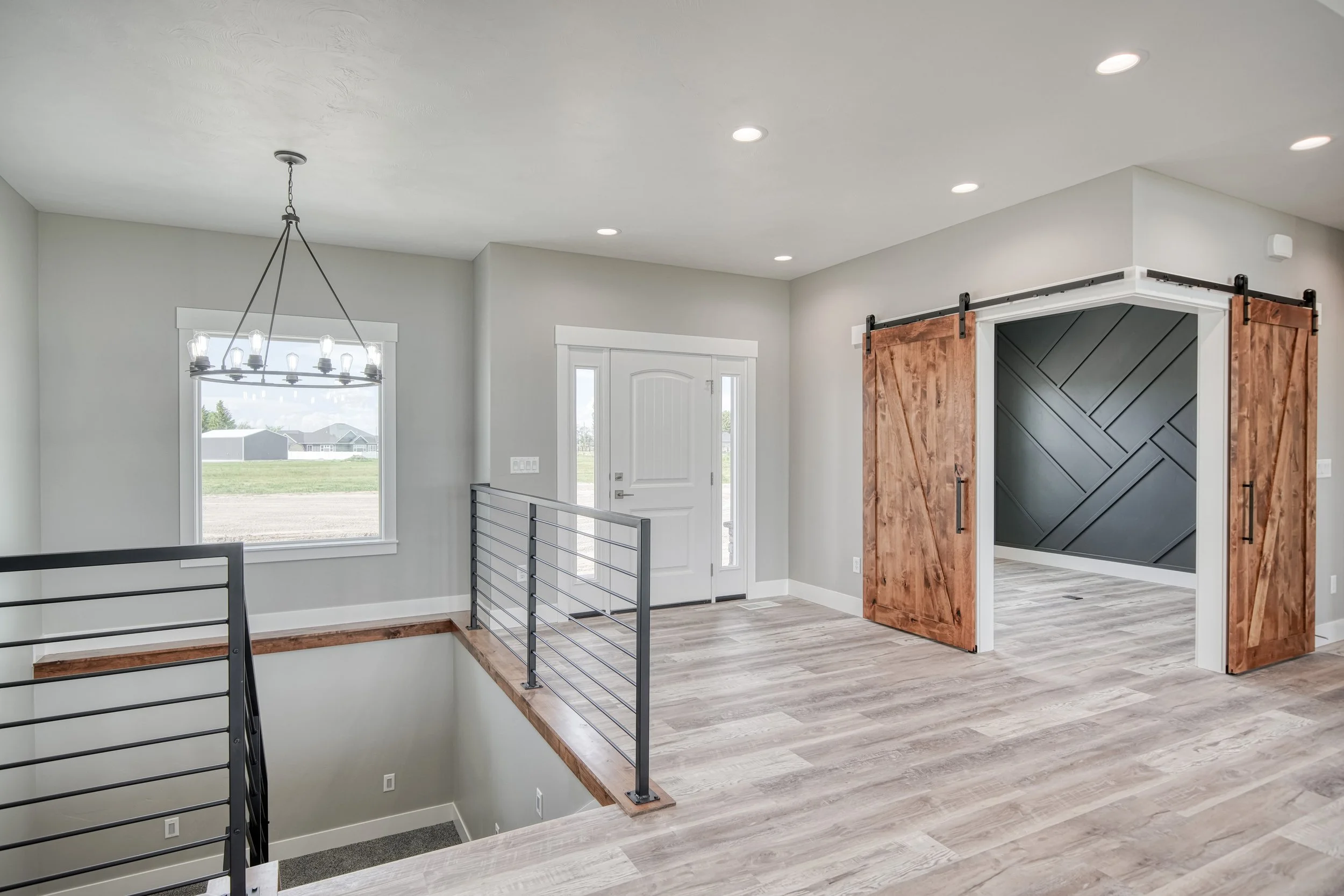 Entry area beside an open staircase and wood cabinetry — JAB Construction’s Modern Craftsman custom home in Idaho Falls, Idaho.