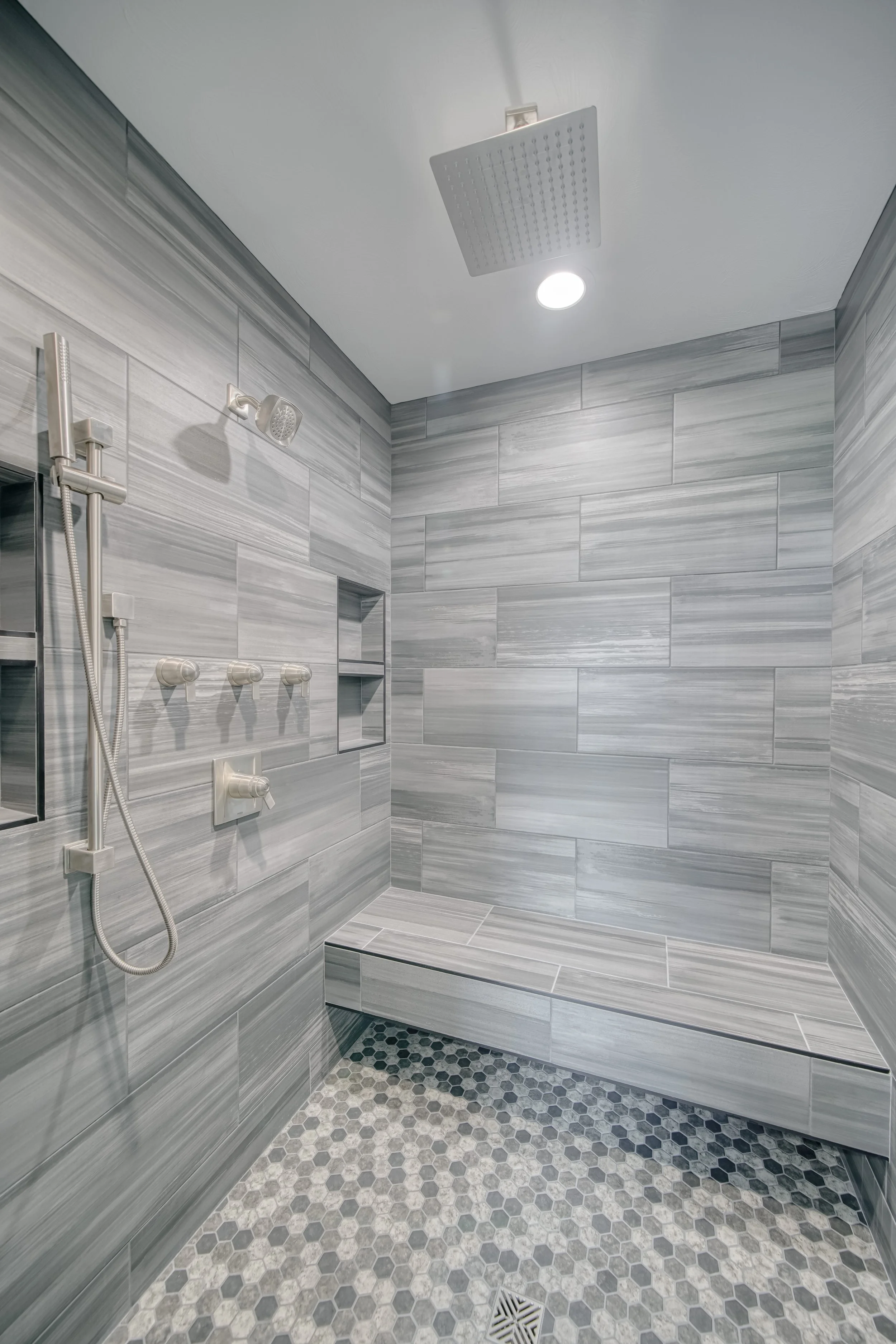 Tiled walk-in shower with a built-in bench — JAB Construction’s Modern Craftsman custom home in Idaho Falls, Idaho.