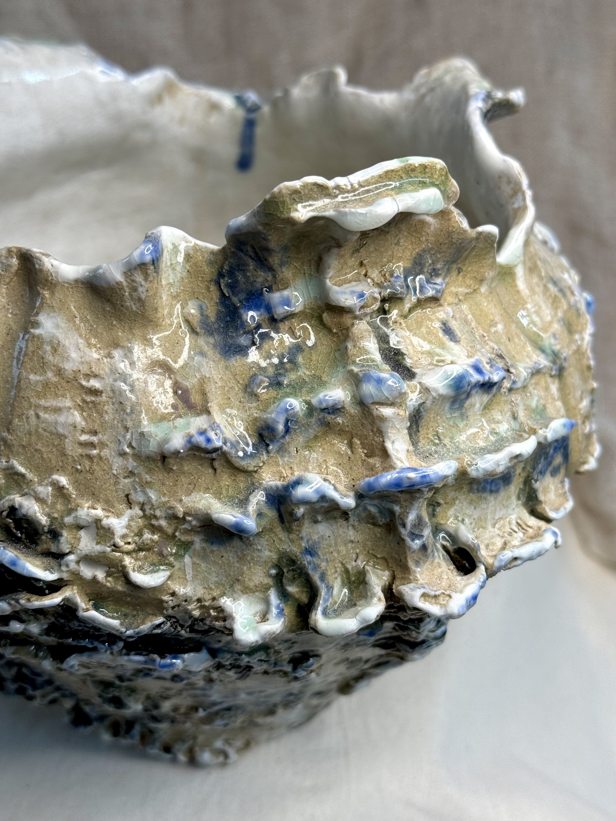 Coast to Clay - This piece is inspired by the sea, heavily textured imprinted with sea shells. A soft layer of porcelain added to the edges and then finished with a blue and green glaze.