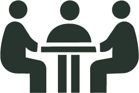 Three people sitting around a table, engaged in a discussion or meeting.