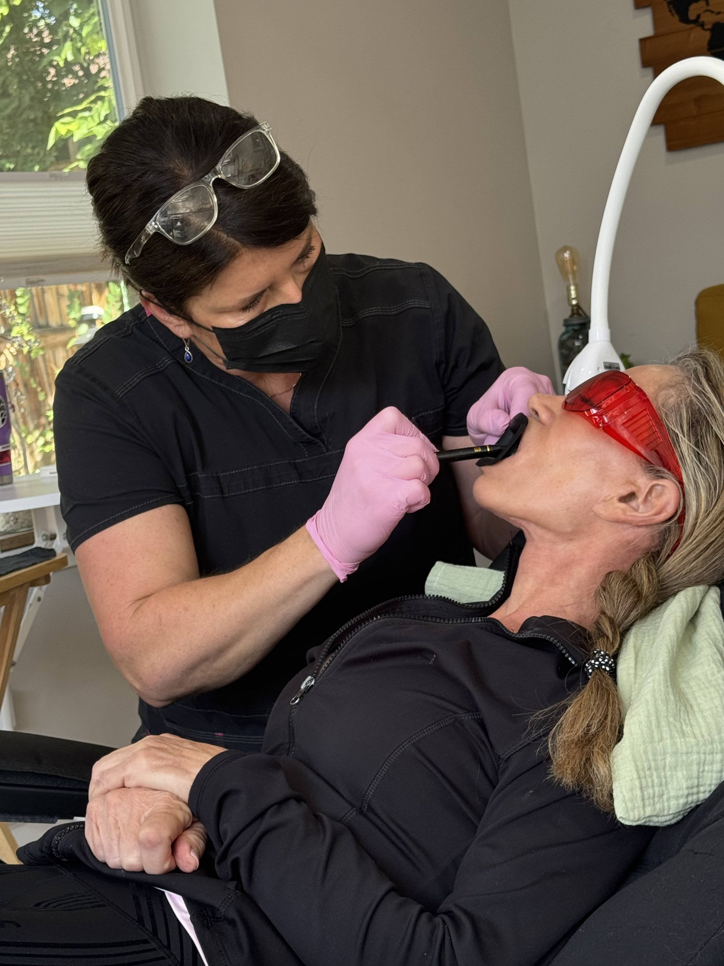 Sarah giving one of her patients a brighter smile at her luxury whitening studio in the Denver Highlands.