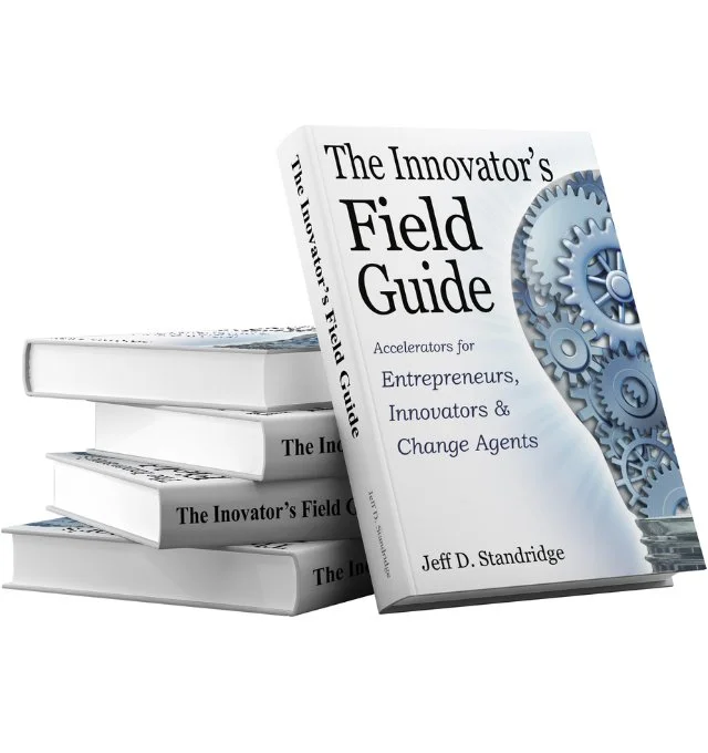 A stack of four books titled "The Innovator's Field Guide," with the top book leaning against the others, featuring gears on its cover.