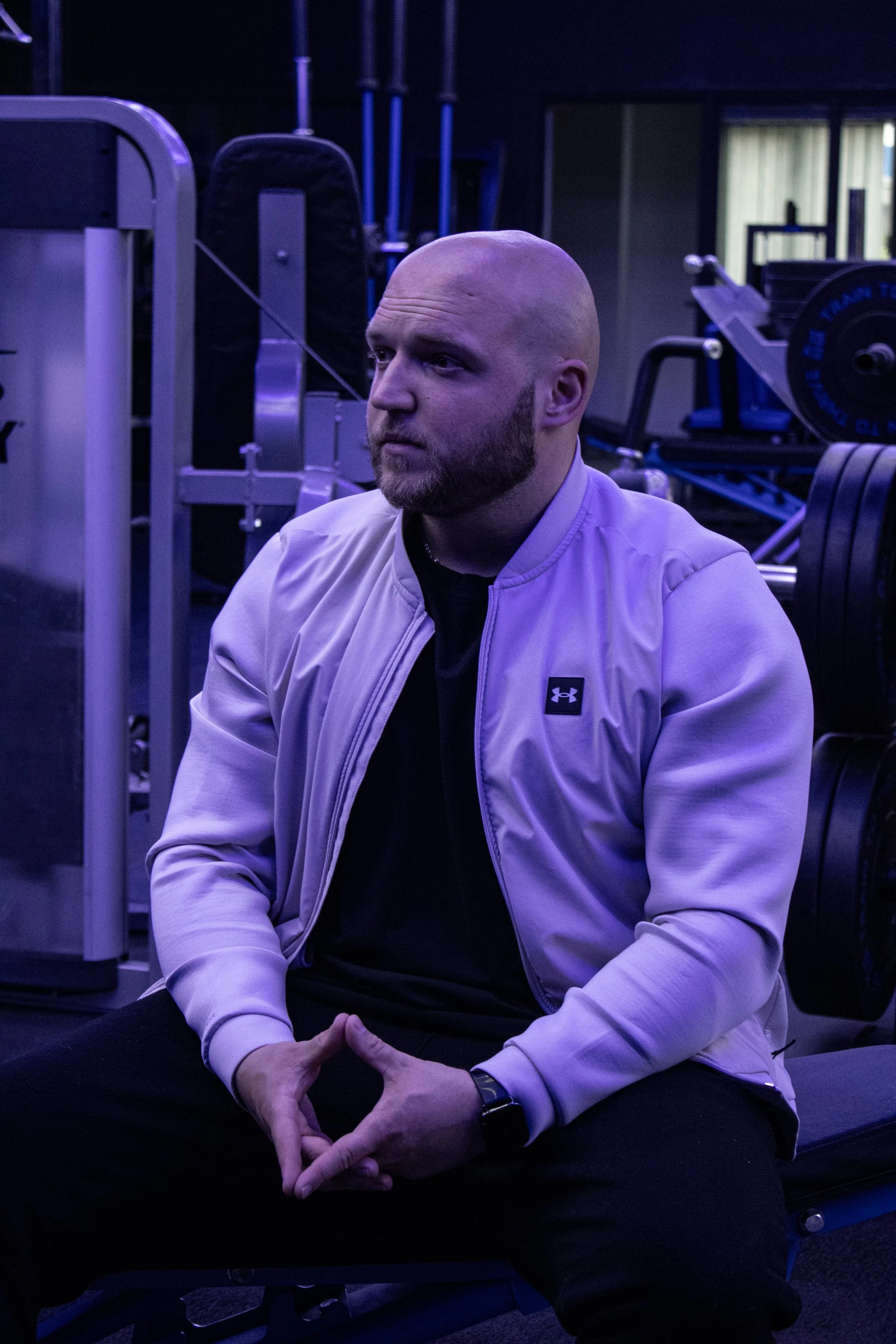 Mateusz Rys sitting quietly in the gym looking thoughtful, a reminder that heavy winter days happen to everyone