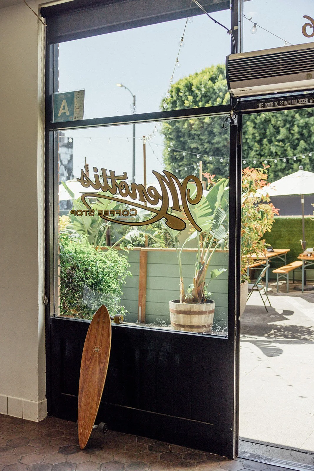 The Menotti's Coffee Stop script on the front window, looking out to the patio