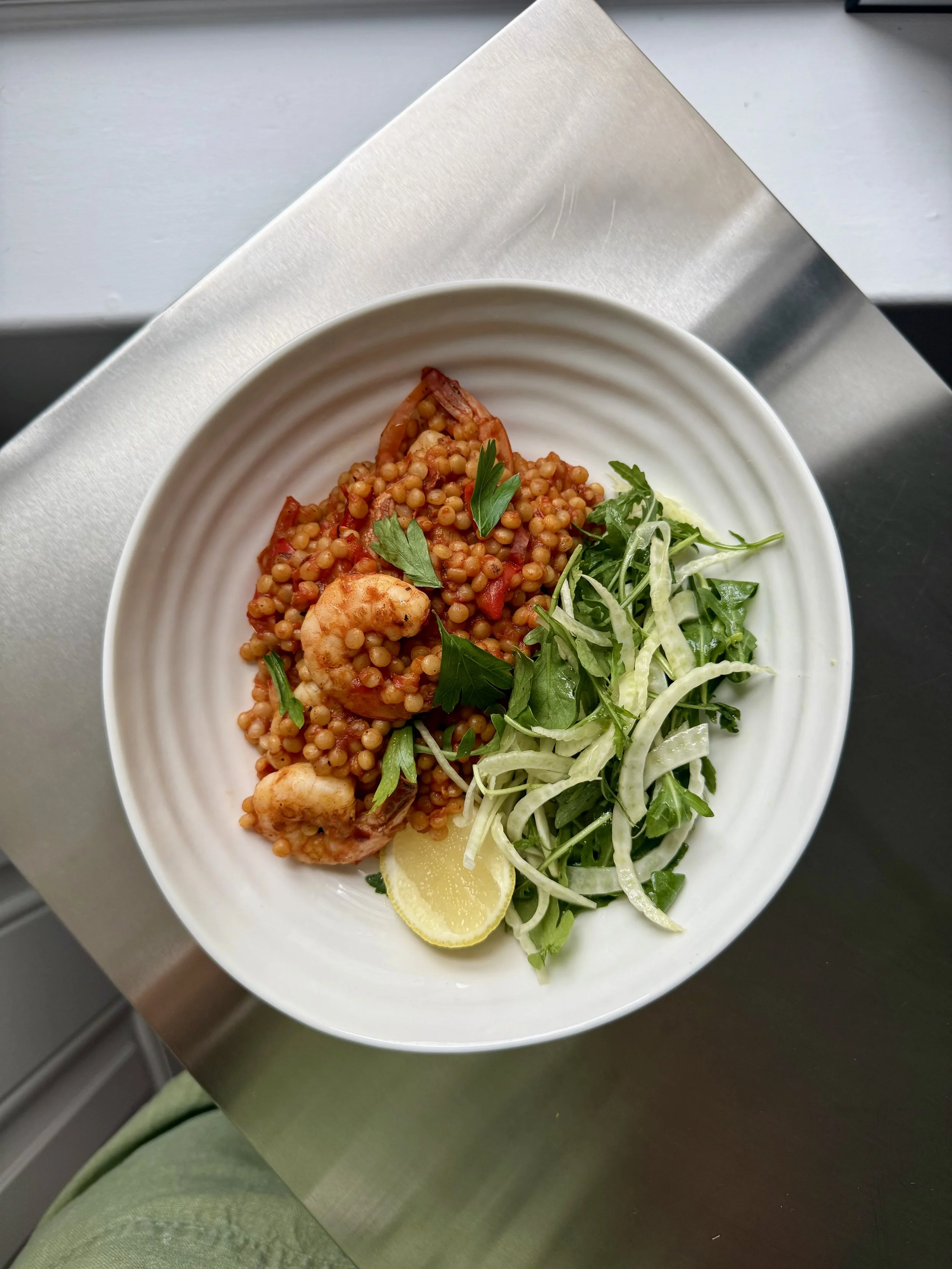 Prawn and giant cous cous paella served with a fennel and rocket salad