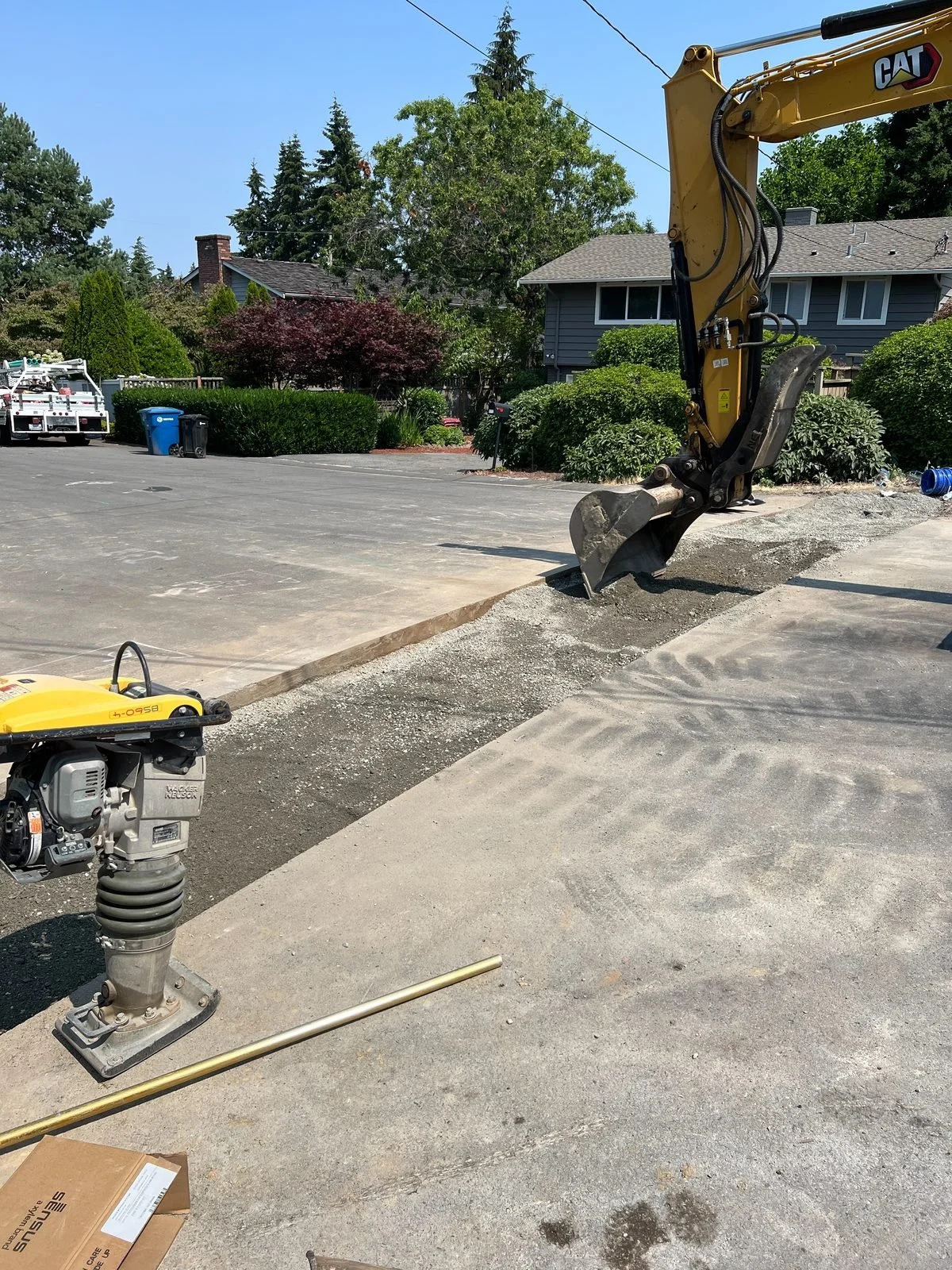 Excavator and compactor preparing a utility trench