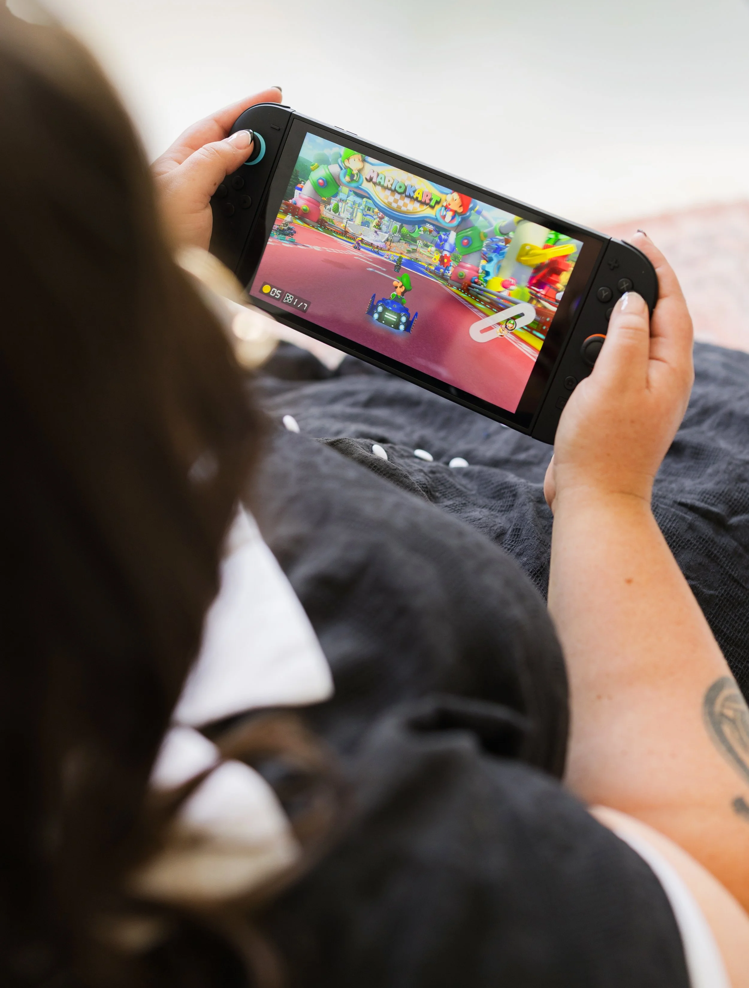 Person playing Mario Kart on a handheld gaming console.