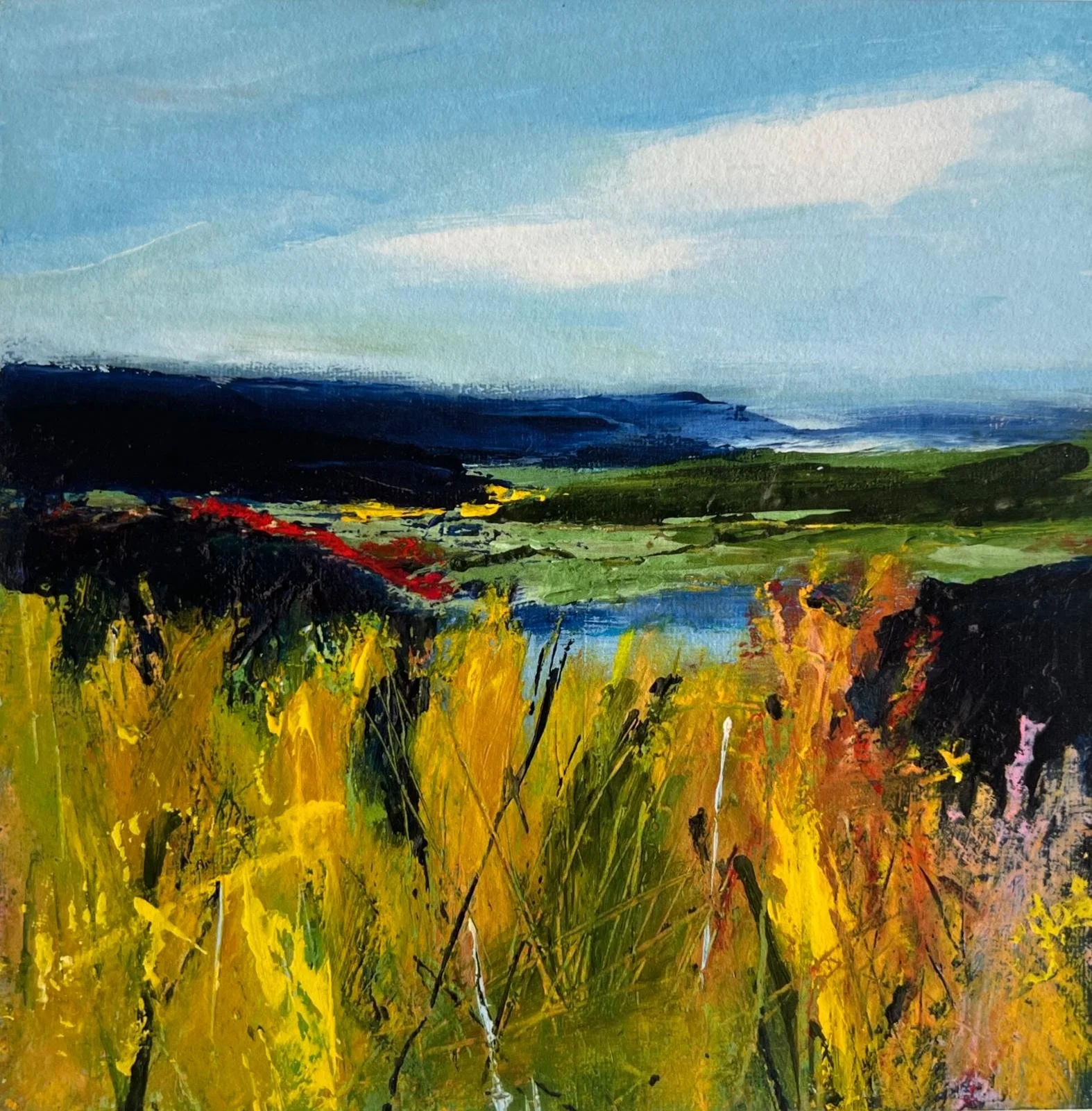 A colourful landscape painting featuring a field of yellow and red flowers in the foreground, with green hills and deep blue mountains in the background under a cloudy sky.