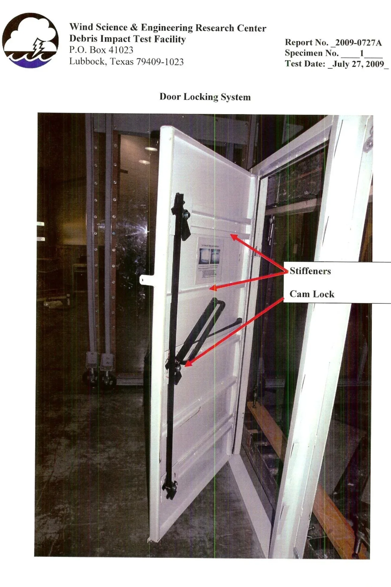 Photo of a door locking system installed on a white door. The system includes stiffeners and a cam lock, and is part of a debris impact test facility at the Wind Science & Engineering Research Center, dated July 27, 2009.