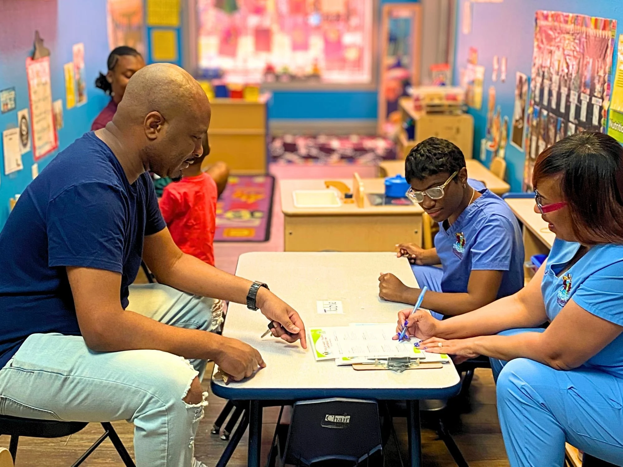 Father meeting with his child’s teachers to discuss the child’s progress at Toddler’s University.