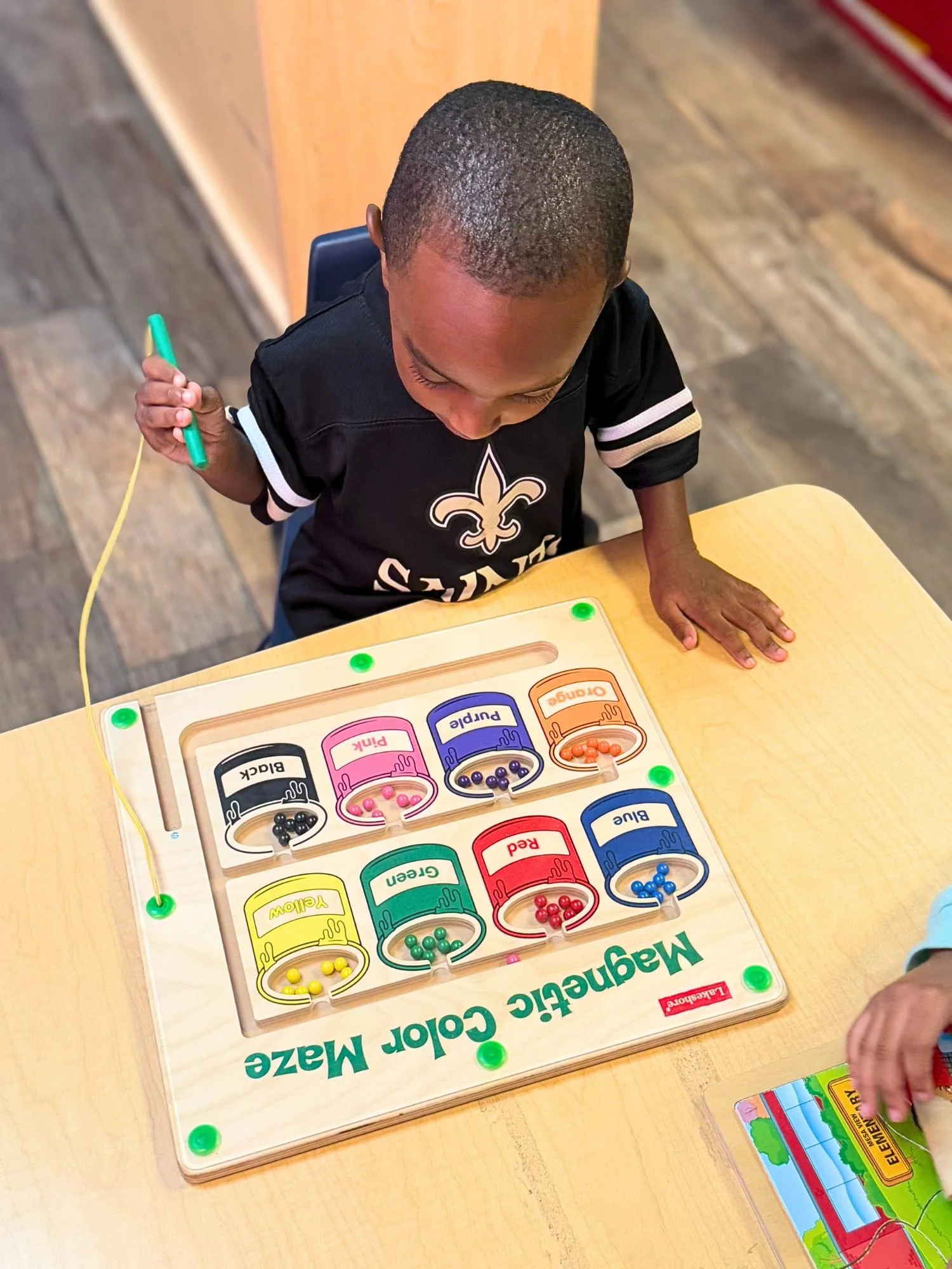 Young boy completes a color-matching maze, matching colors to their corresponding paint buckets.