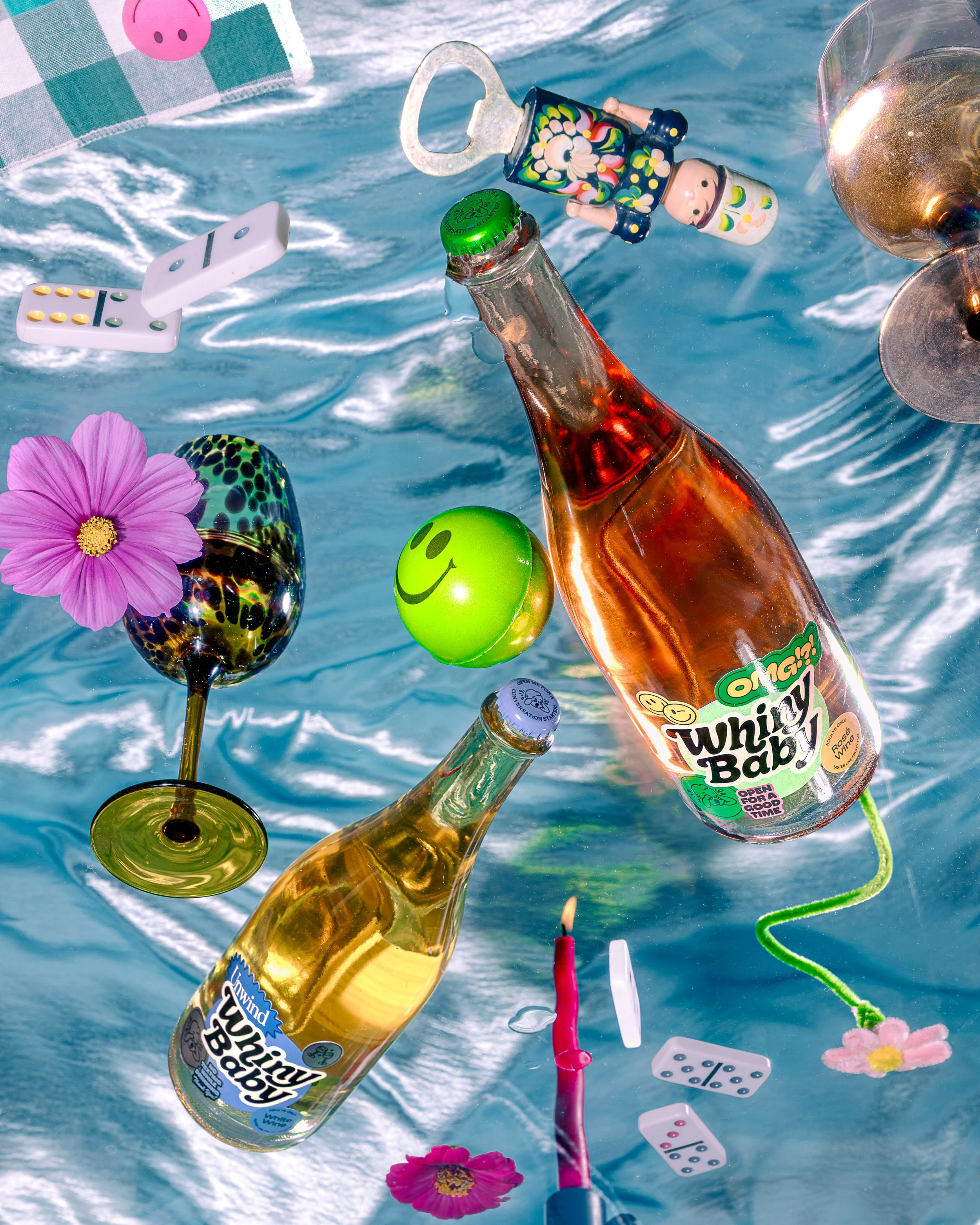 Floating bottles, flowers, dominoes, and a toy among water waves.