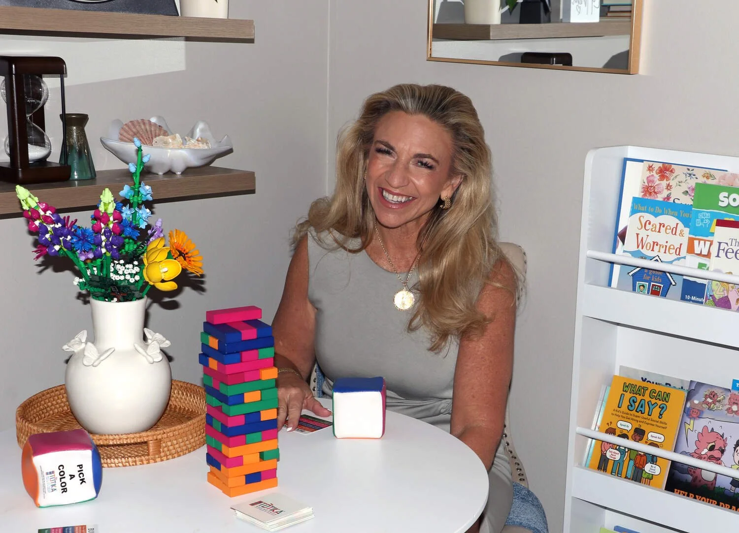 Andrea Schoon sitting in her child therapy office with toys on a table
