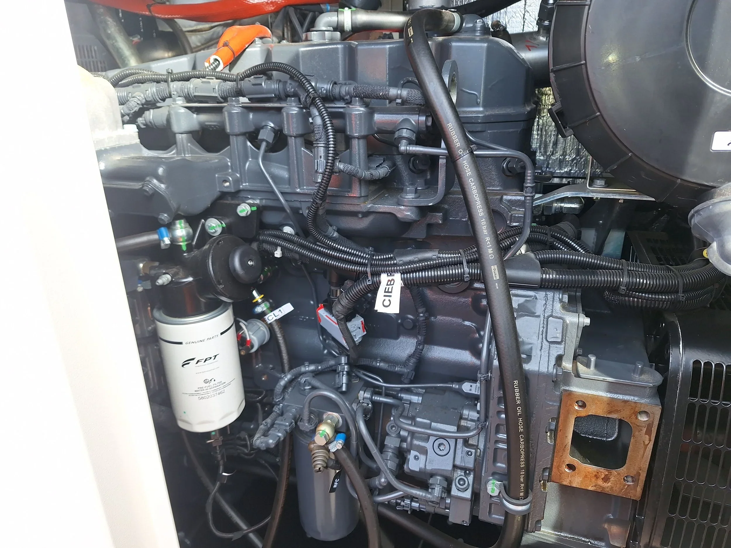 Diesel generator engine with oil filter and hoses during servicing