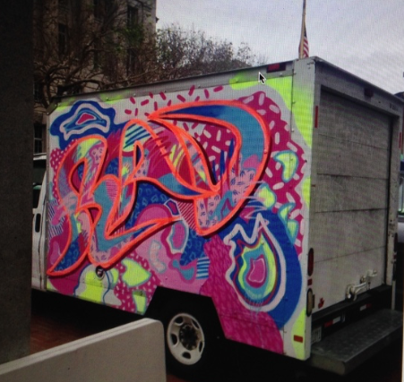 Graffiti art on a white truck featuring vibrant, colorful abstract shapes and patterns.