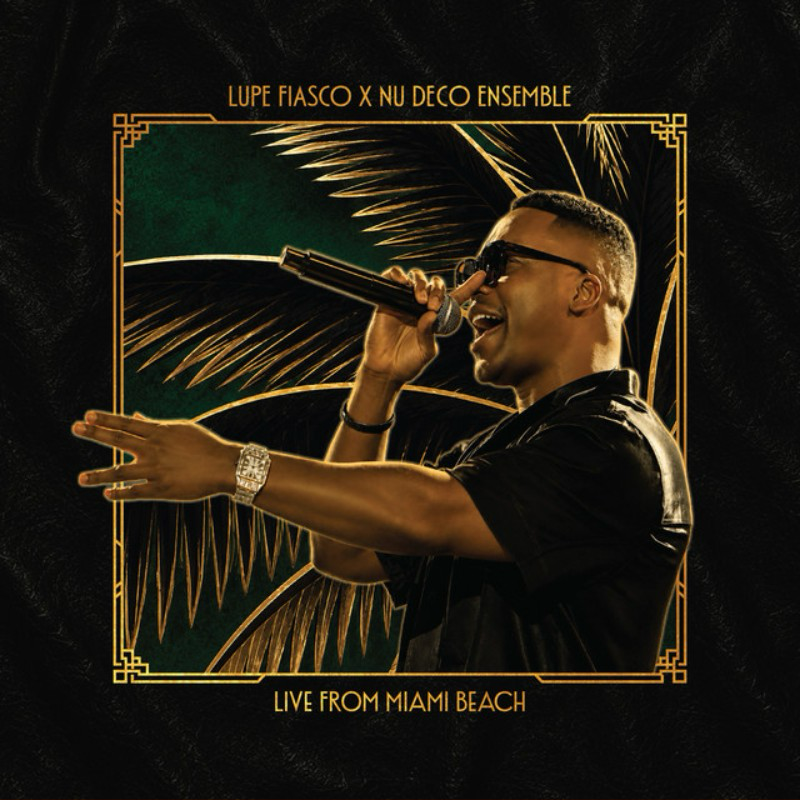 A musician performing with a microphone on stage, surrounded by palm leaves, with golden border and text indicating a live performance from Miami Beach. Lupe Fiasco & Nu Deco Ensemble performing live at Miami Beach.