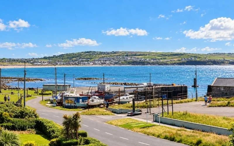 Liscannor Harbour on Clare’s Atlantic coast offers a quiet place to pause, with small fishing boats, stone quays and coastal views across the bay.