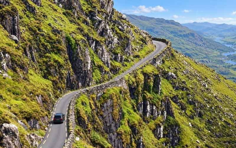 Conor Pass winds through mountain scenery above the Dingle Peninsula, with views across steep valleys and lakes offering a striking contrast to the nearby coast.