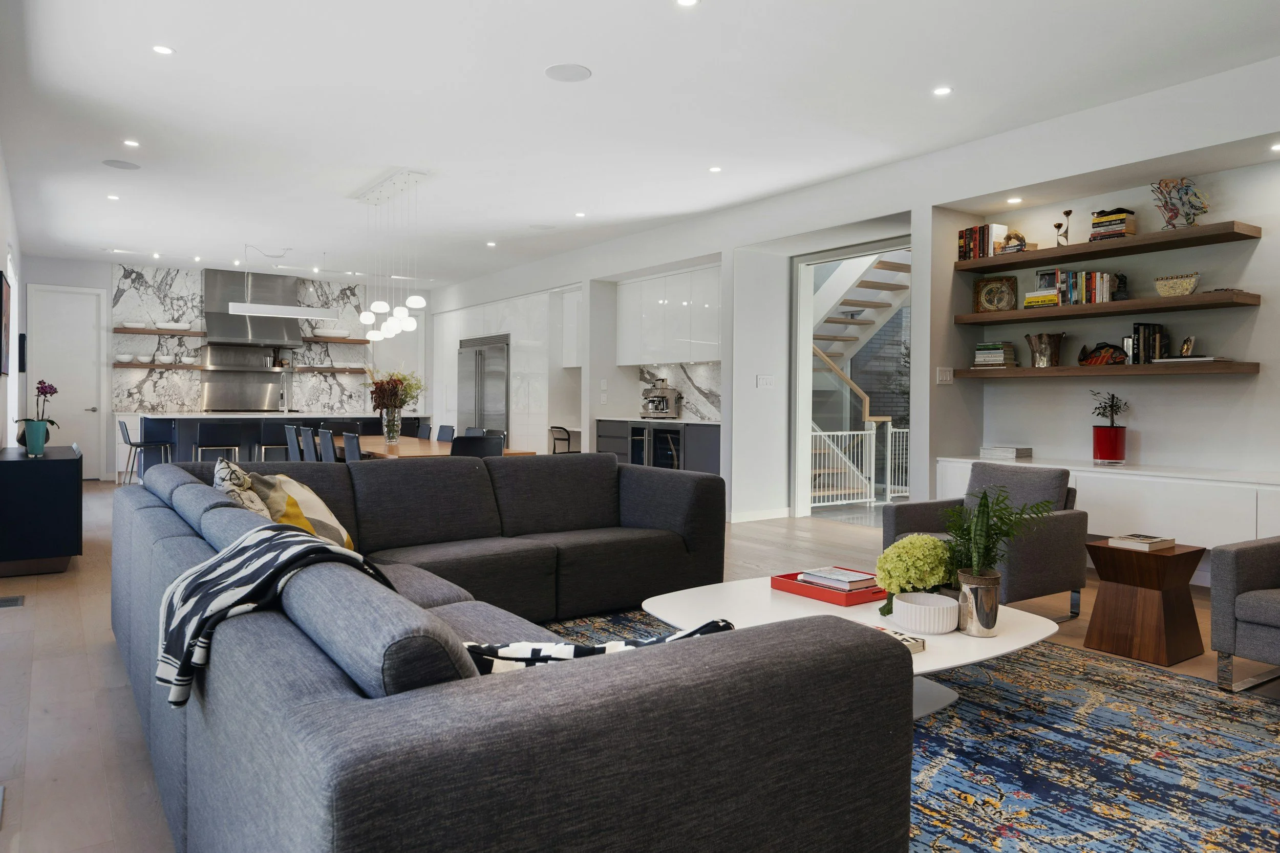 Open-plan living room and kitchen with comfortable seating, built-in shelving, and natural light.