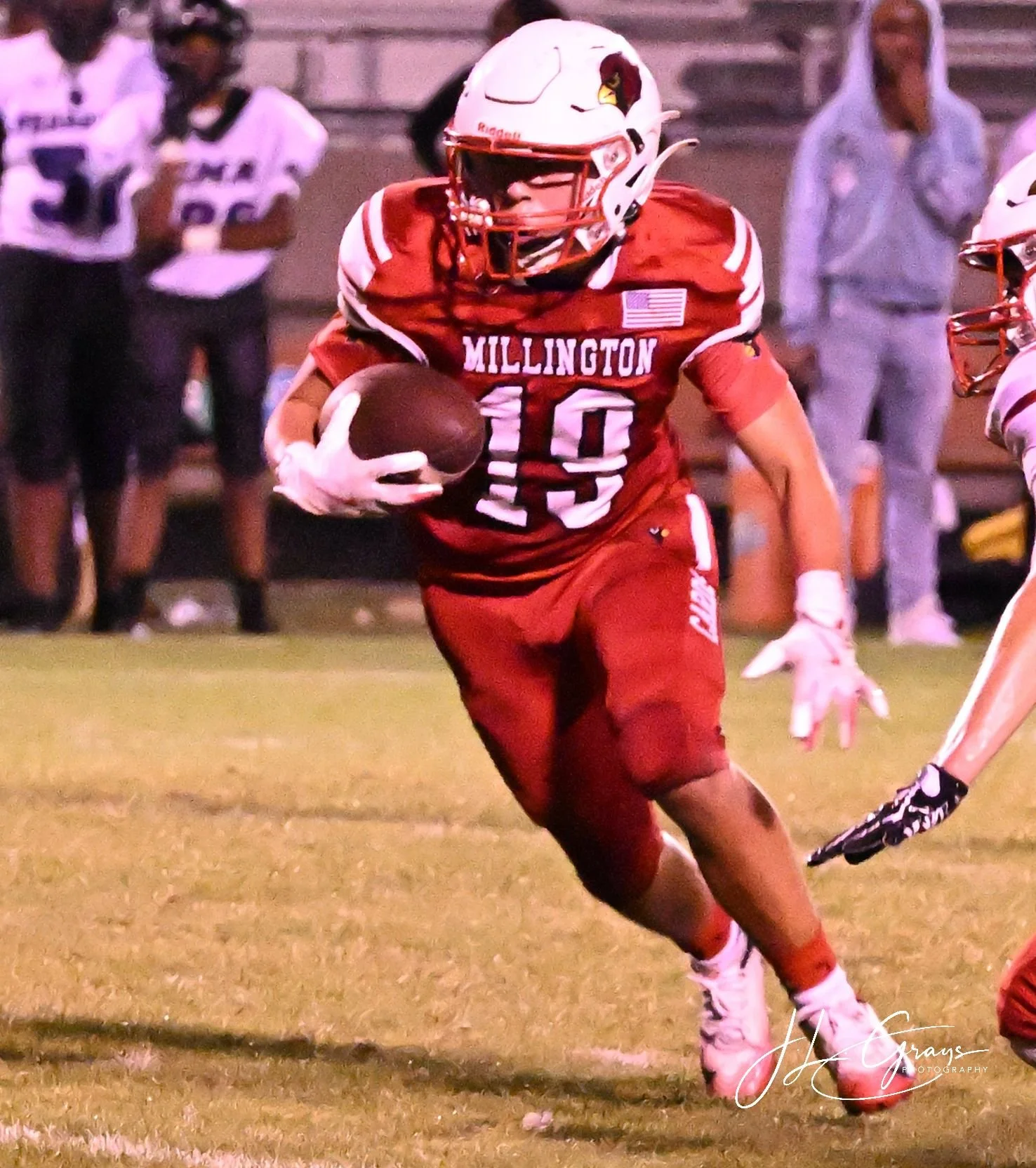A football player in a red uniform running with the ball during a game.