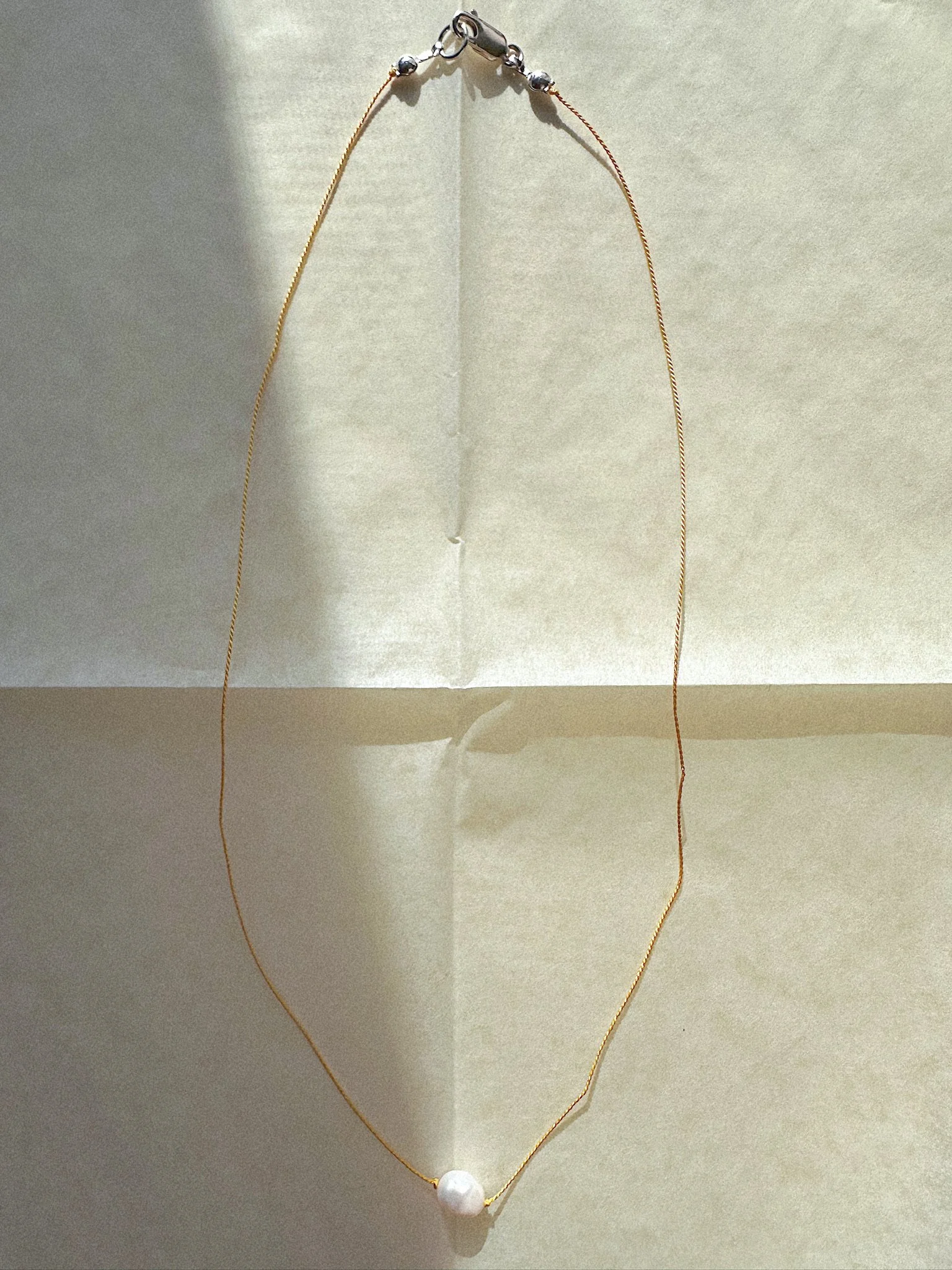 Single freshwater pearl necklace hand-knotted on yellow colorful silk thread