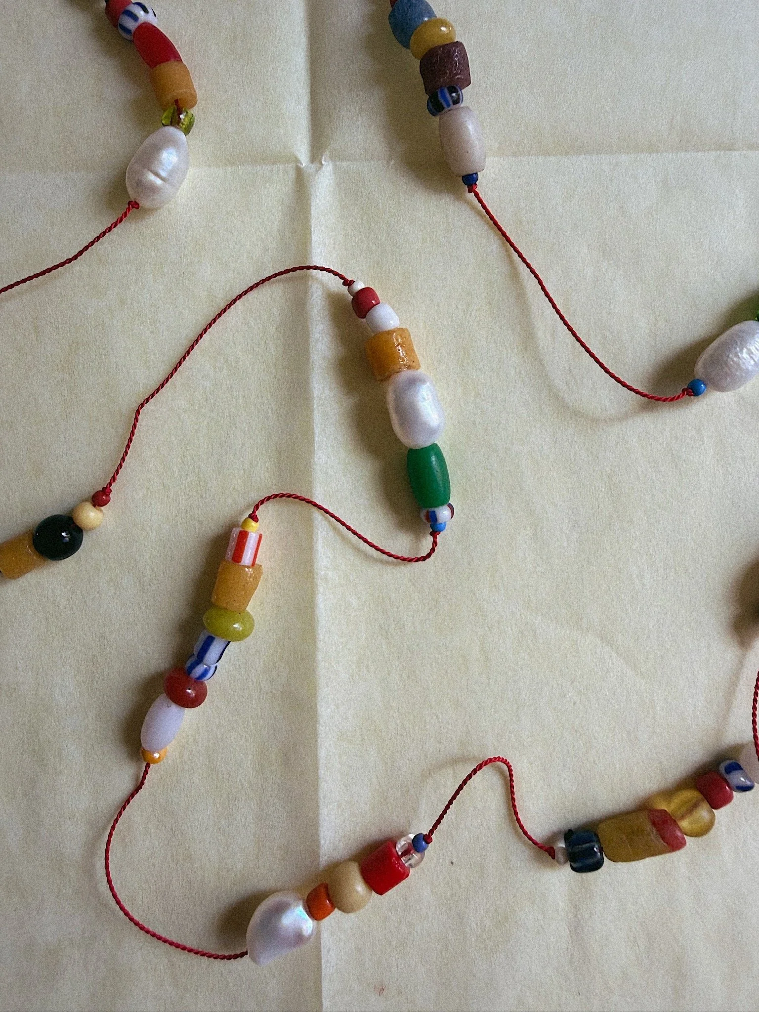 Colorful beads and pearls on silk draped organically and shot from above