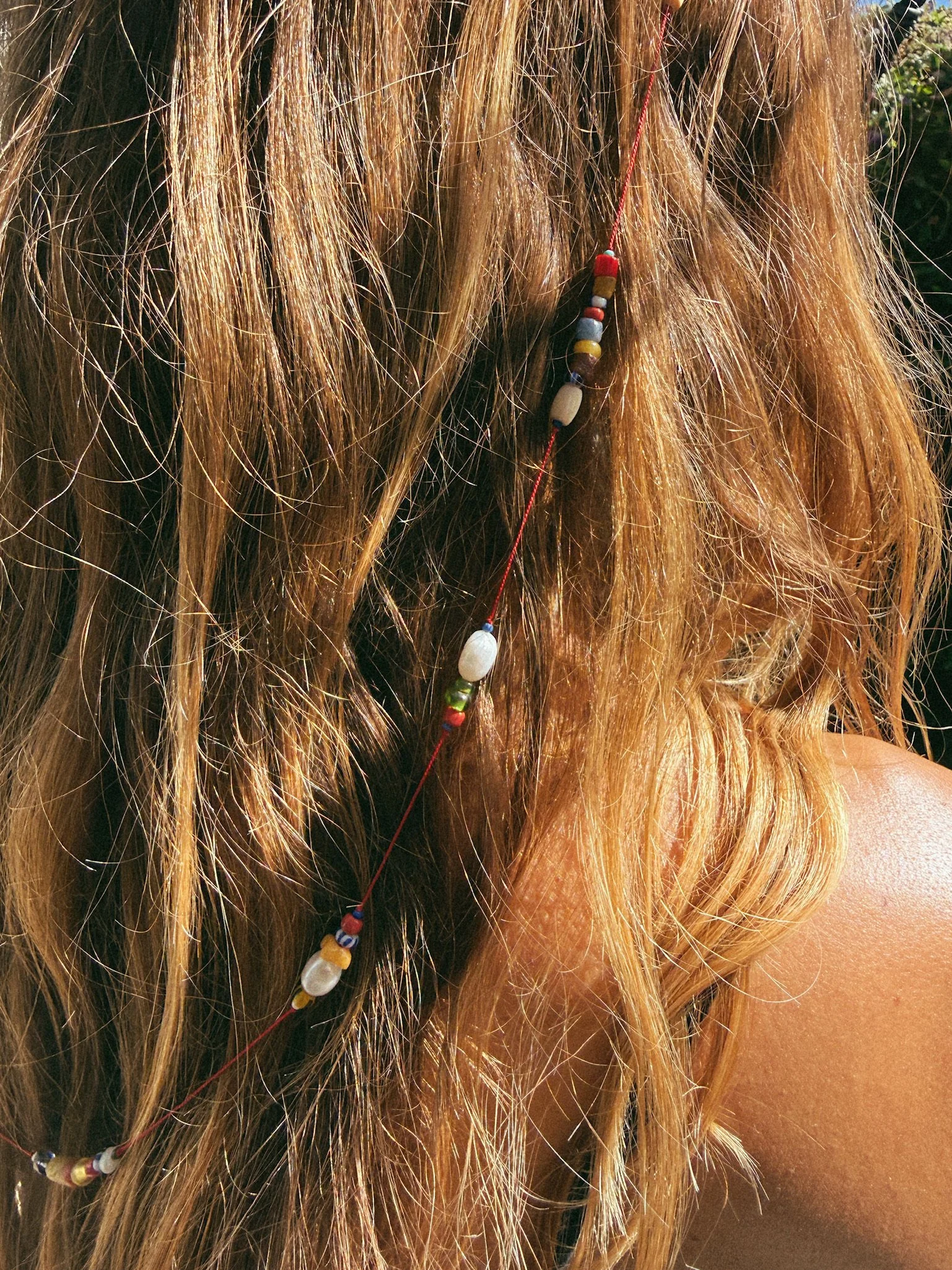 Colorful bead and pearl glasses chain on red silk show draped in long hair
