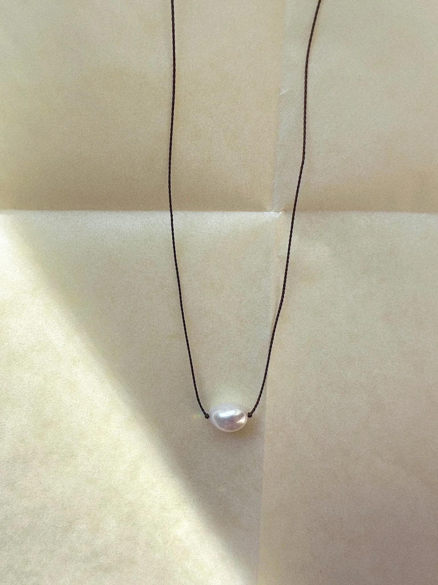 Single freshwater pearl necklace hand-knotted on brown silk thread