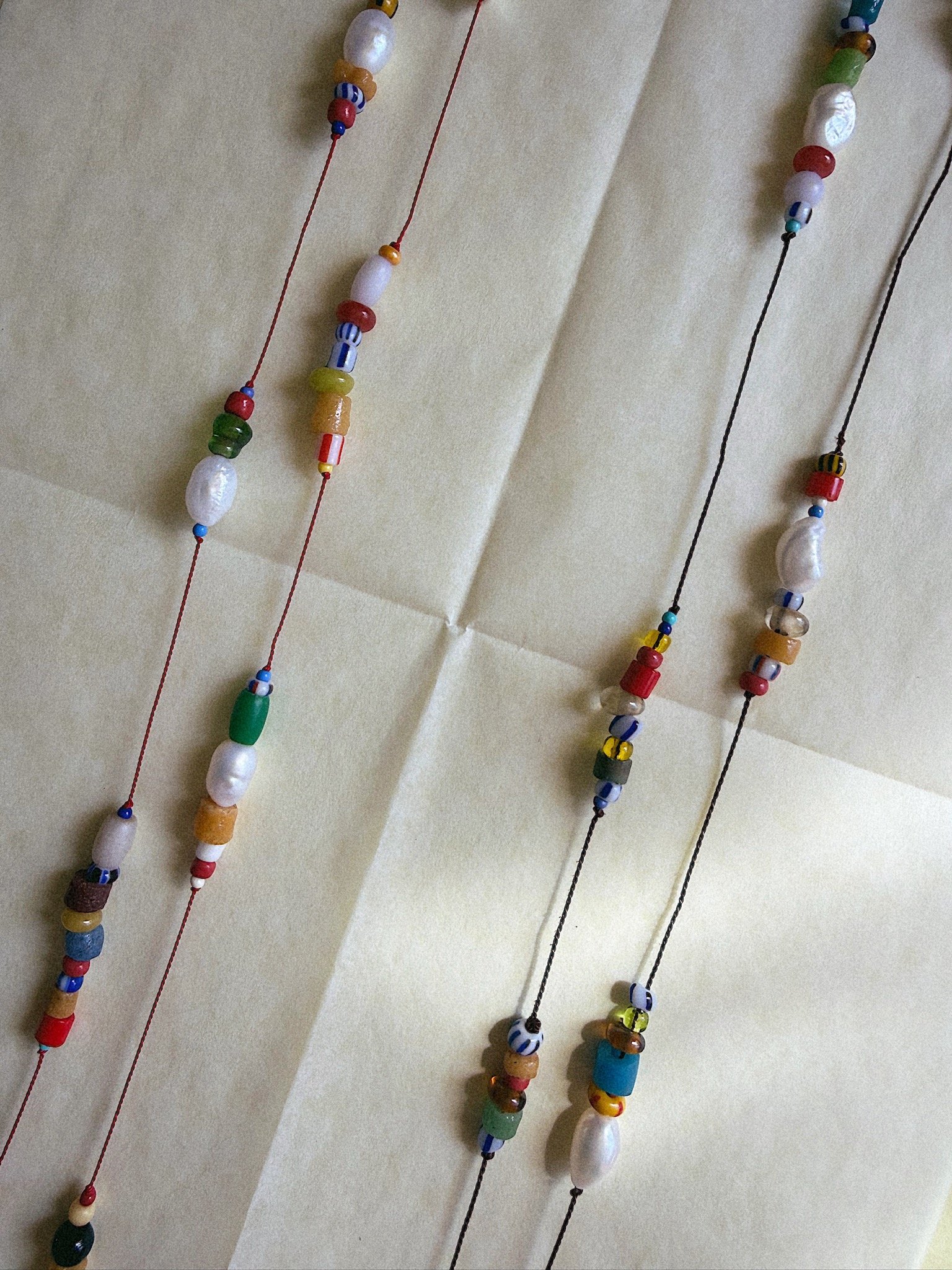 colorful beads and pearls on silk shot from above