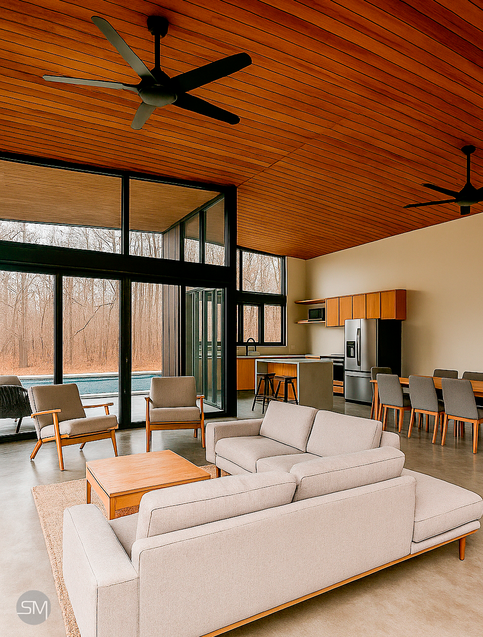 Interior of a modern living room with a high wooden ceiling, ceiling fans, glass doors leading to an outdoor pool area, and a dining and kitchen space with wooden cabinets and stainless steel refrigerator.