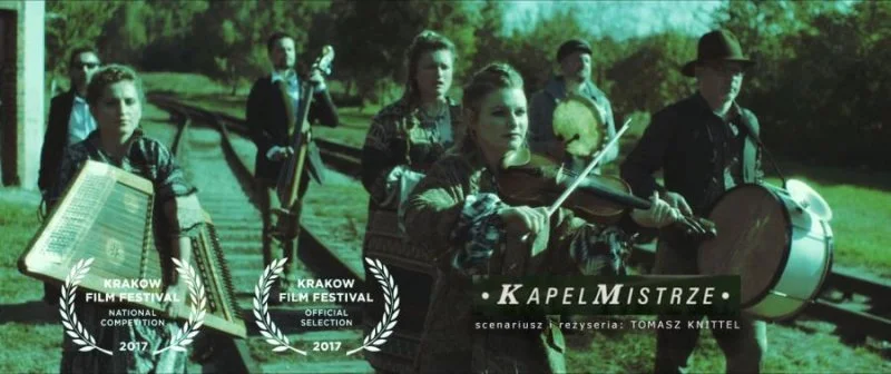 Group of young musicians playing instruments outdoors, holding drums and a violin, with trees and grass in the background, promotional text for Krakow Film Festival 2017 and film titled 'Kapel Mistrz'