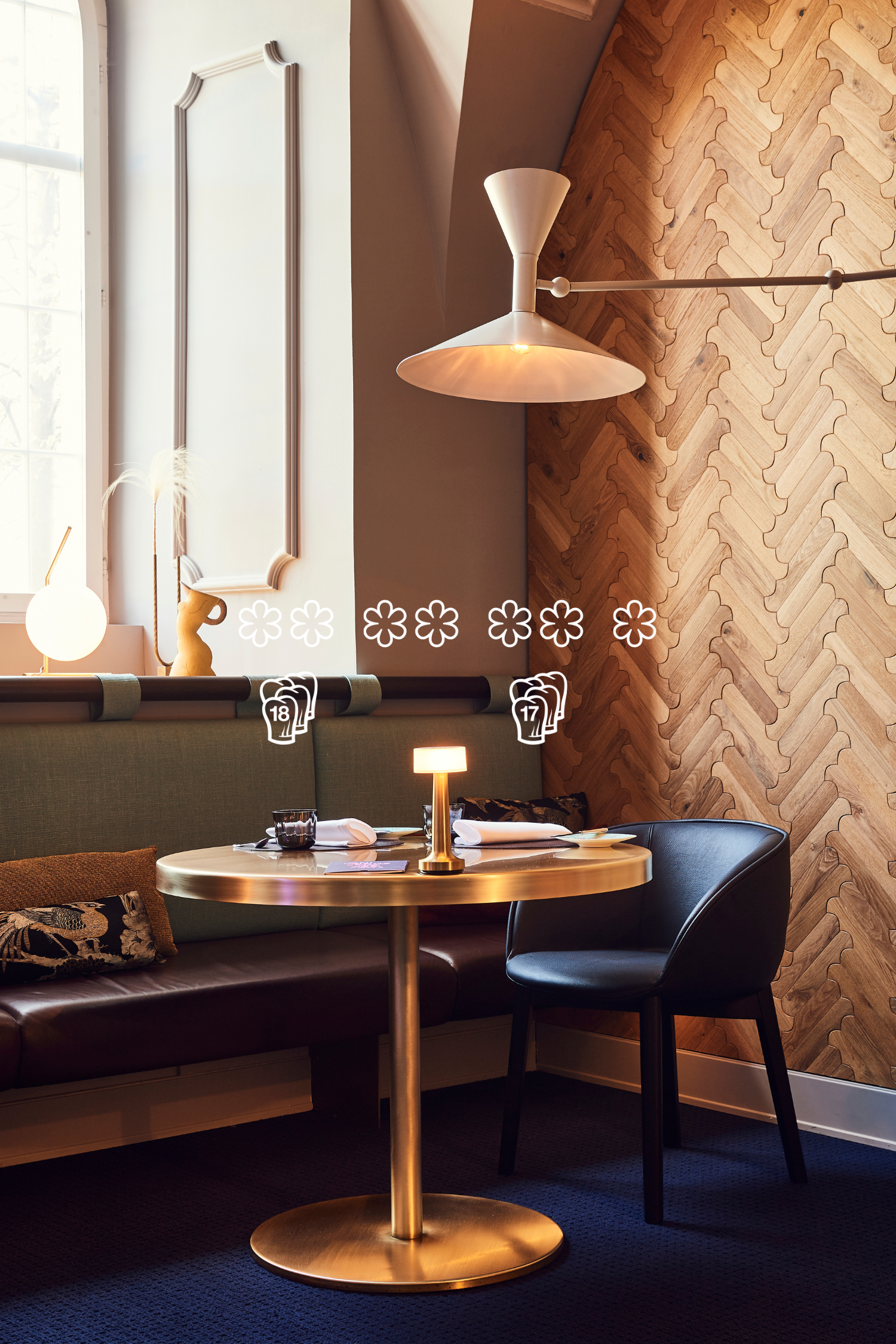 Restaurant mit rundem goldenem Tisch, grüner Sitzbank und Holztäfer – Gastronomie der Caminada Group