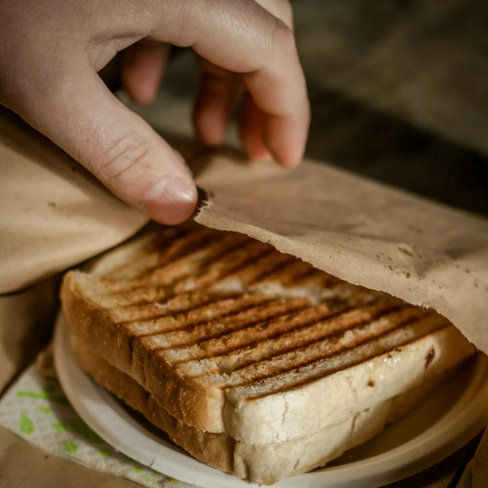 Close-up of sliced white bread and toasted bread slices on a paper-lined tray.