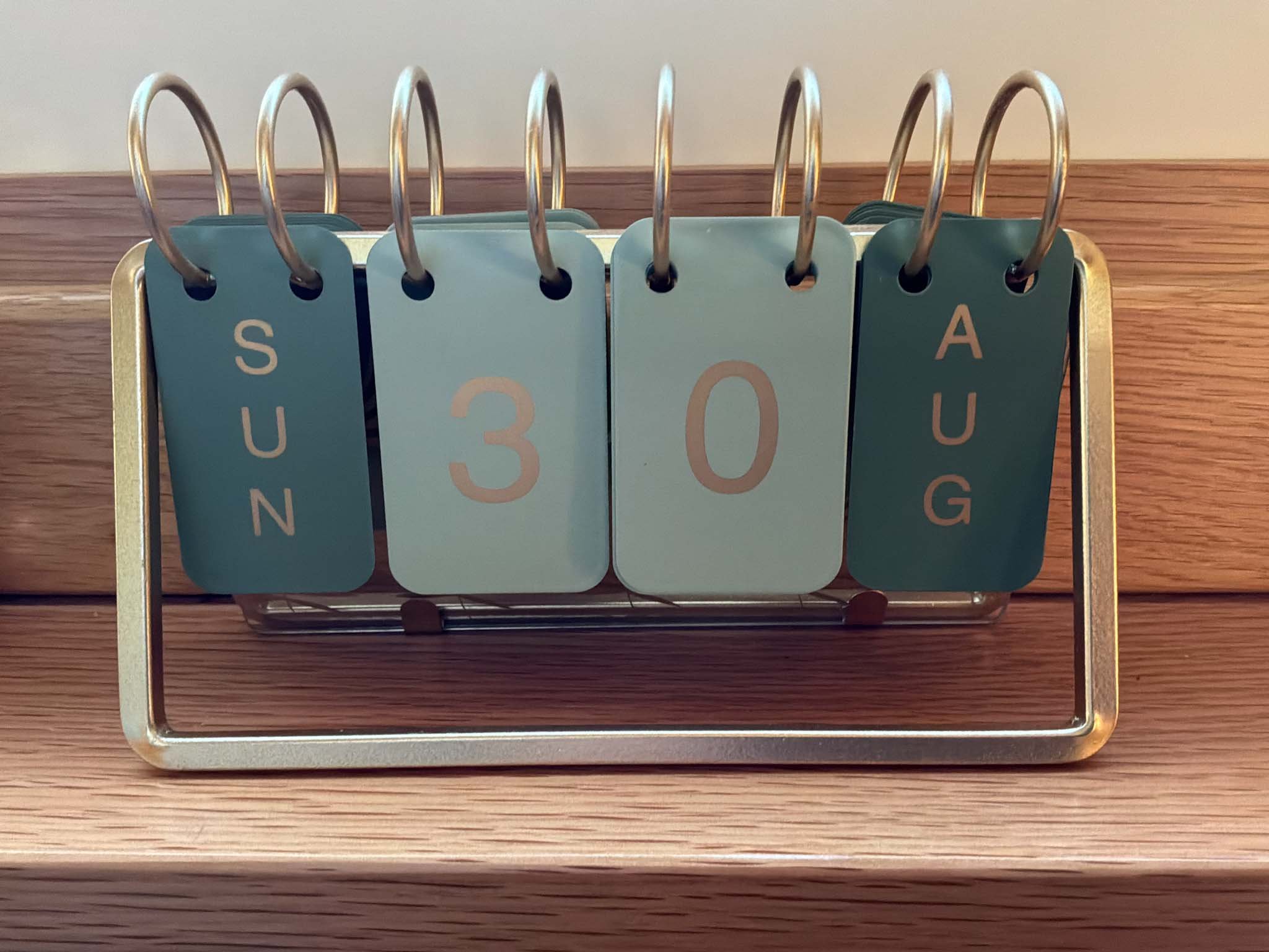 Perpetual calendar with Gold coloured frame and two tone green tabs showing date of Sunday 30th August 2026