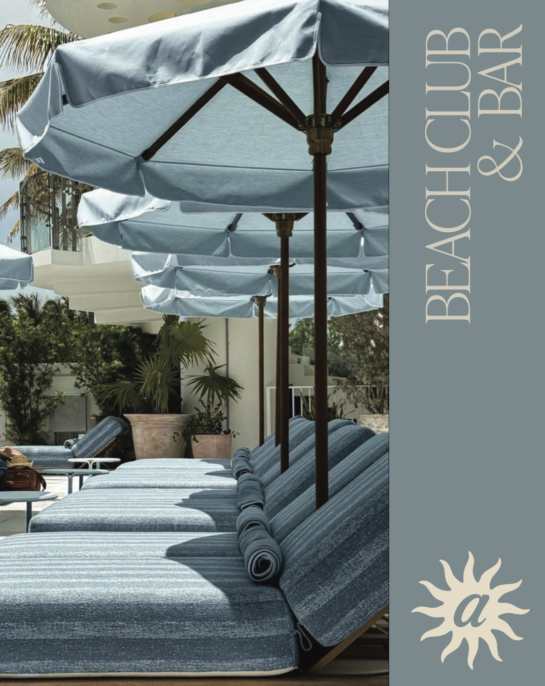 Poolside lounge chairs with blue striped cushions under blue umbrellas at a sunny outdoor area surrounded by plants.