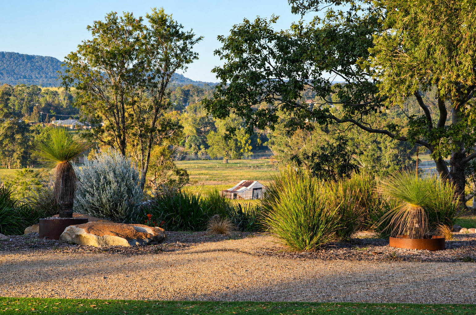 Rural garden with layered naturalistic planting, mature trees and surrounding countryside