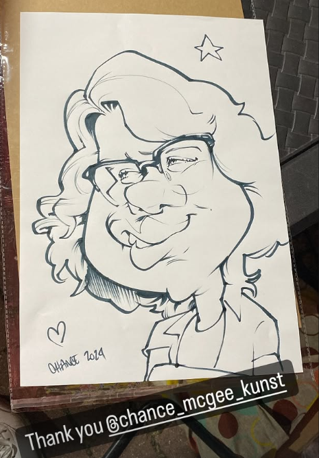 A black-and-white caricature drawing of a woman with glasses, glasses, and wavy hair, with a star and a heart in the background, signed 'Charlotte 2014'.
