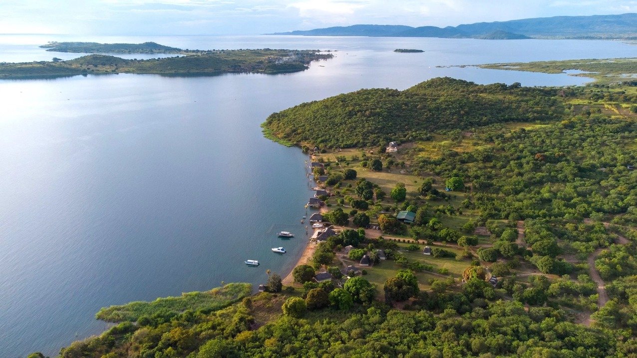 Aerial view of Lake Shore Lodge on the shores of Lake Tanganyika, Tanzania, surrounded by forest and the Kipili islands.