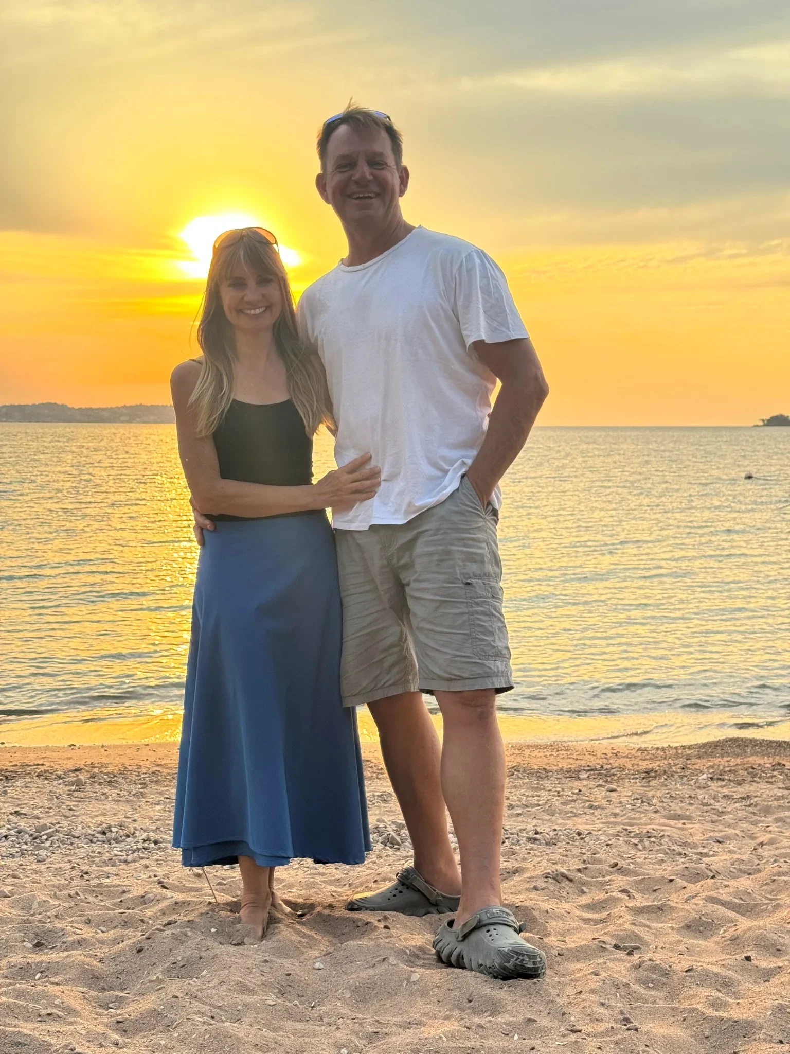 Chris and Louise, owners of Lake Shore Lodge, enjoying a golden sunset on the shores of Lake Tanganyika, Tanzania.