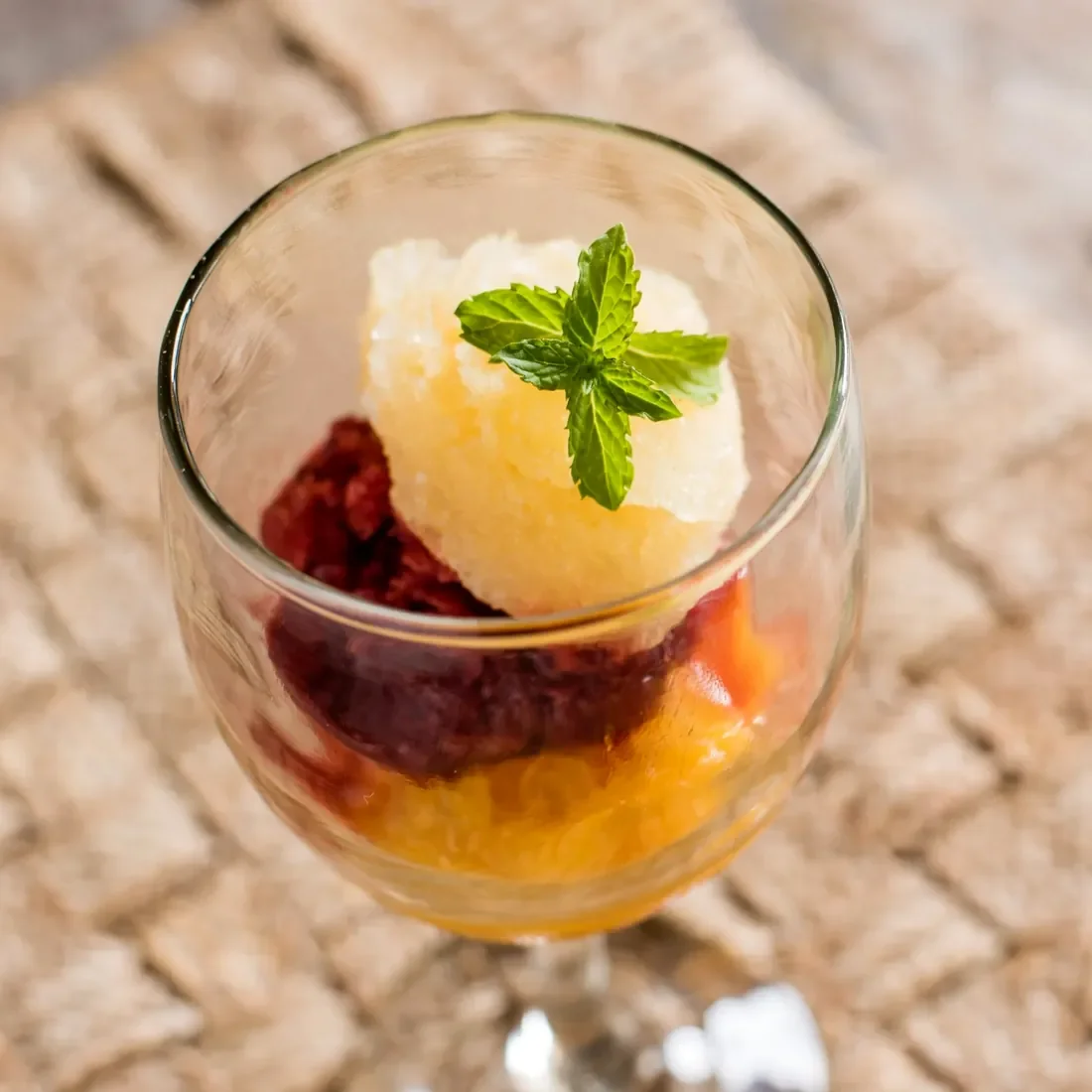 Colourful layered fruit granita served in a glass and garnished with fresh mint at Lake Shore Lodge restaurant, Lake Tanganyika, Tanzania.