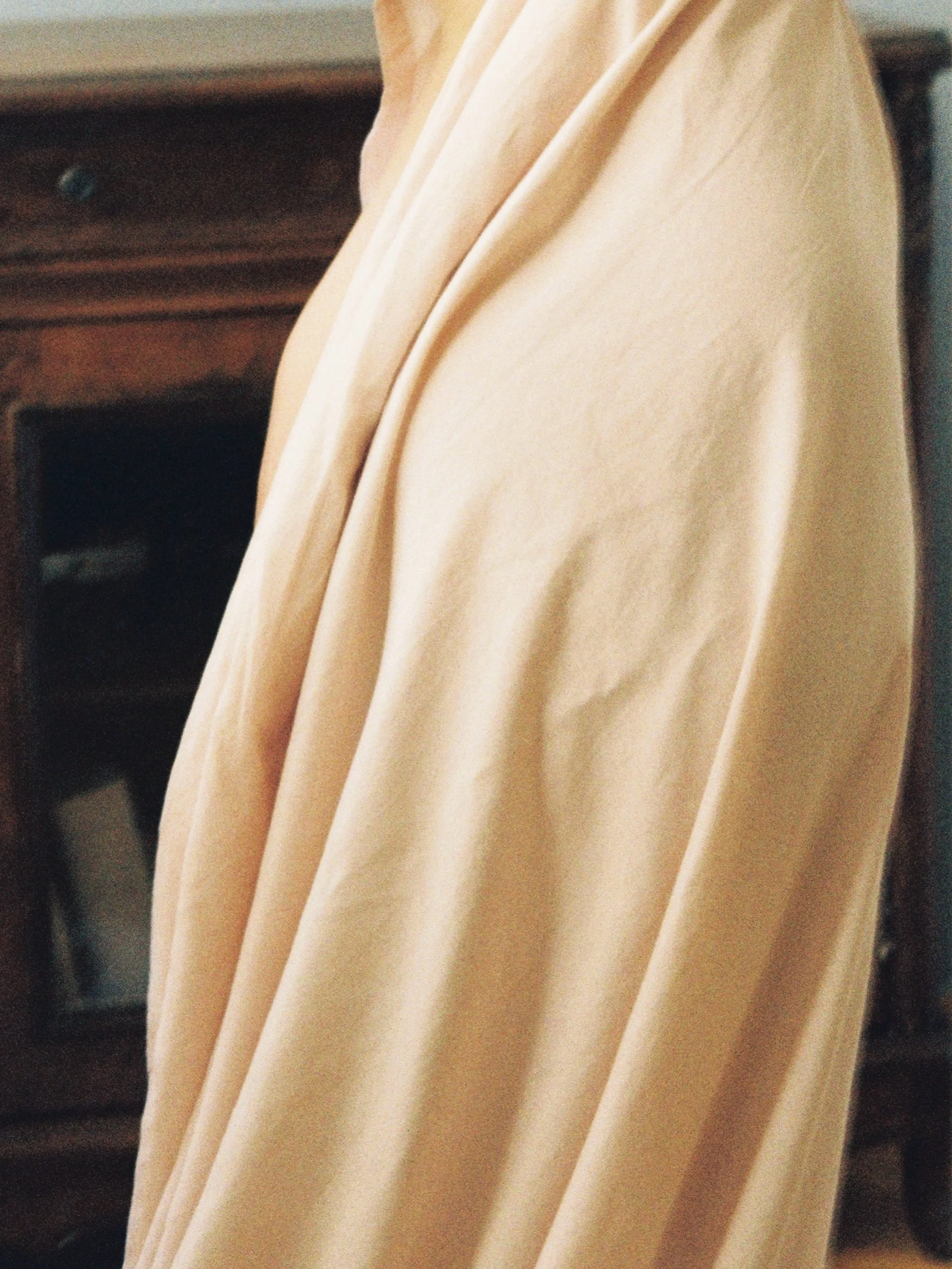 Close-up of beige fabric with soft folds and draping.