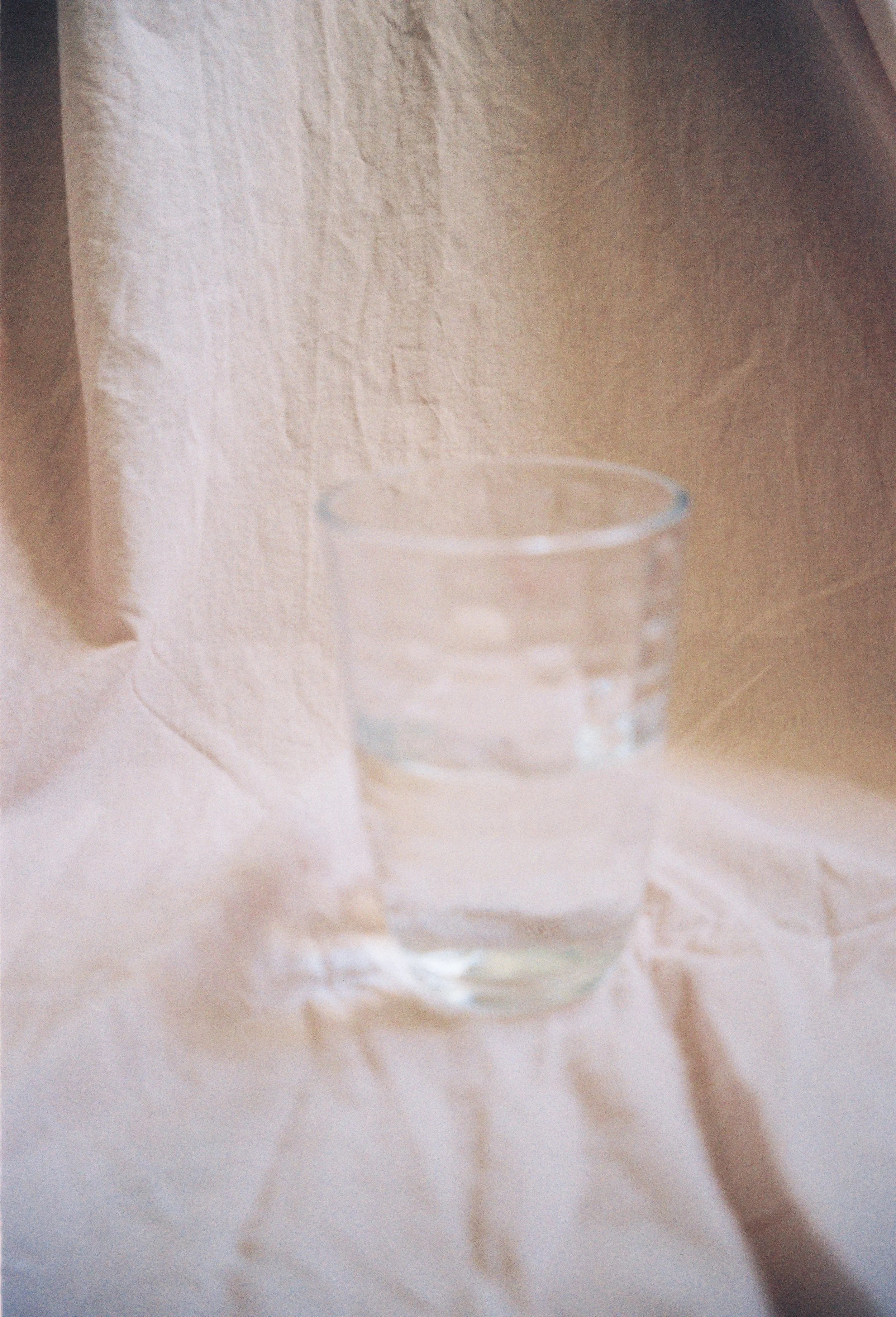 A glass of water on crumpled pink background