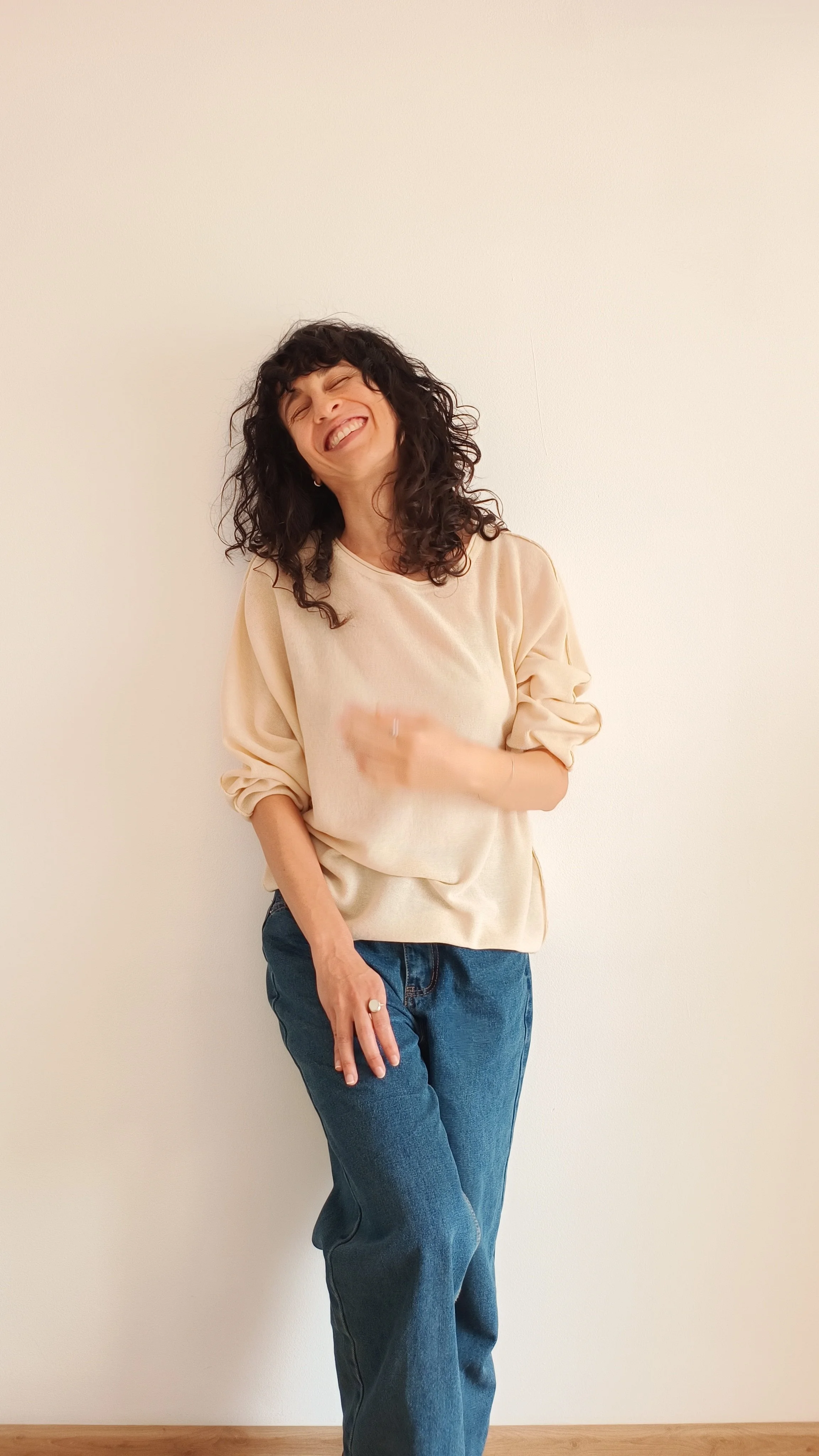 Marta, creadora de lumbral, apoyada en una pared y riendo.