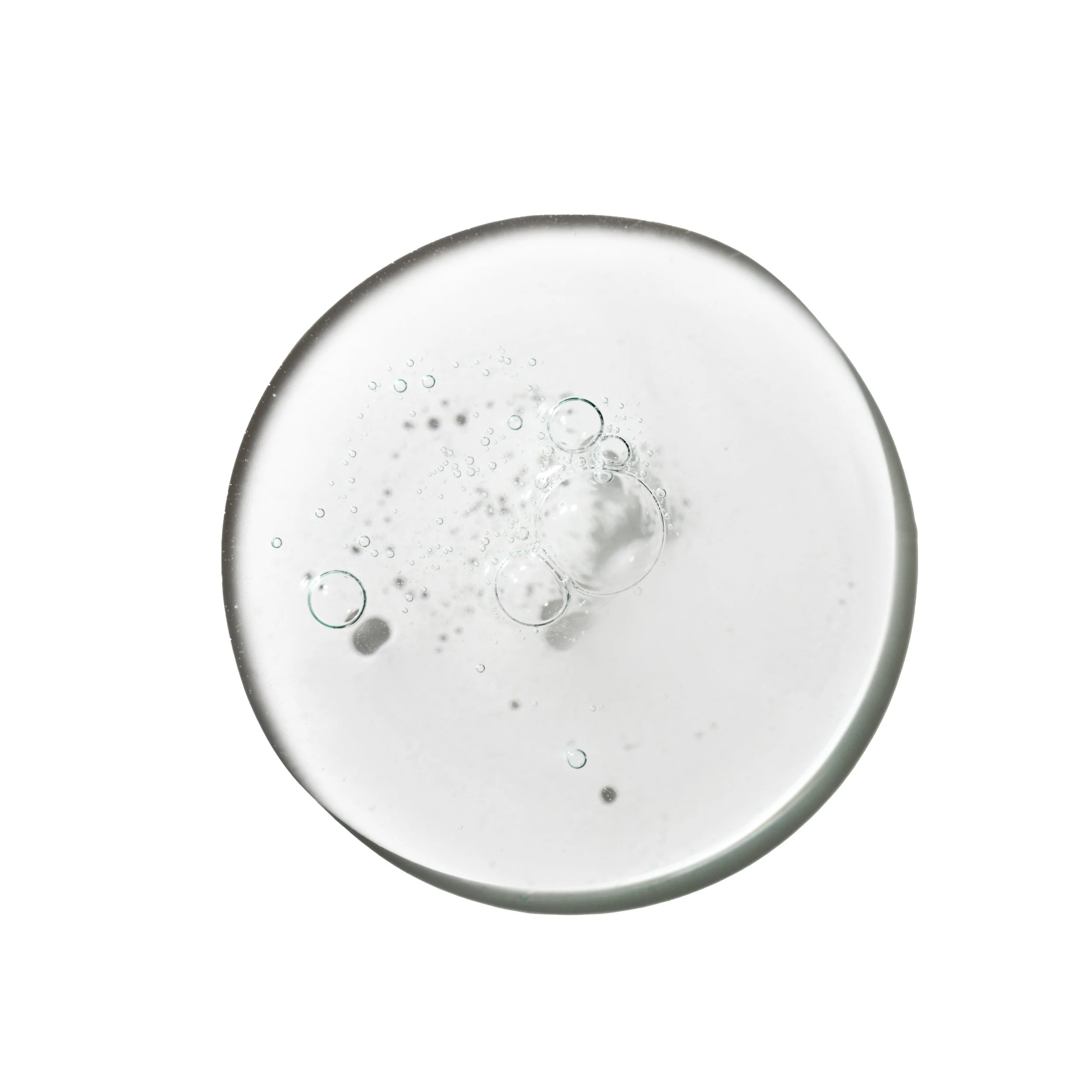 Close-up of a clear glass with tiny bubbles inside, seen from an angle against a white background.
